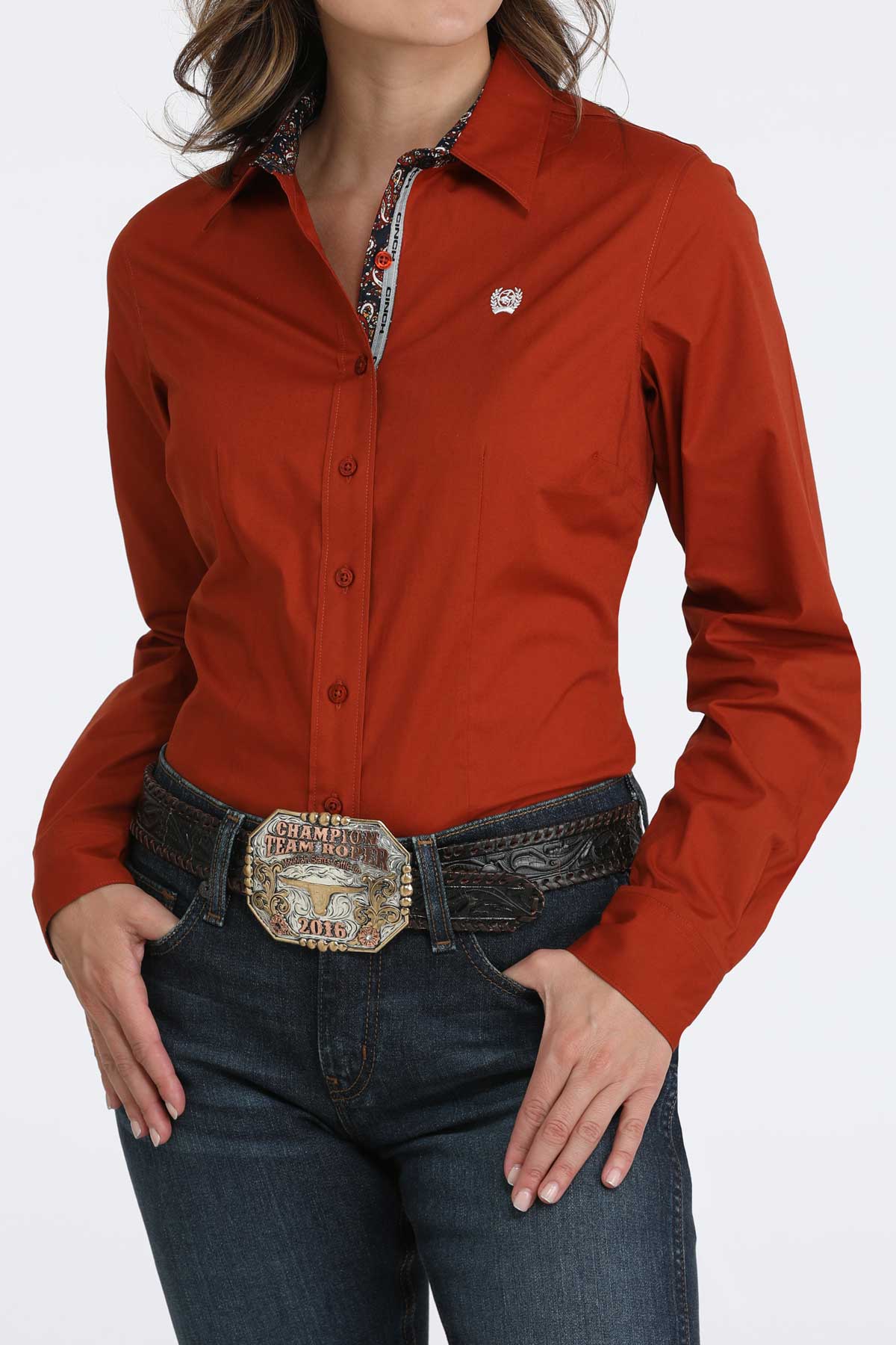 Woman wearing a red long sleeve button-down with jeans and a belt