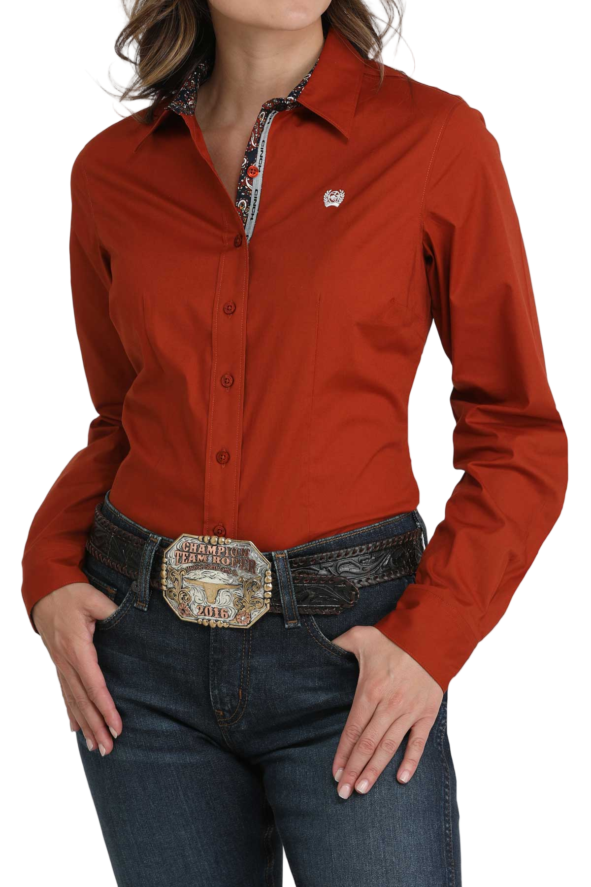 Woman wearing a red long-sleeve button-down shirt, paired with jeans and a large western belt buckle