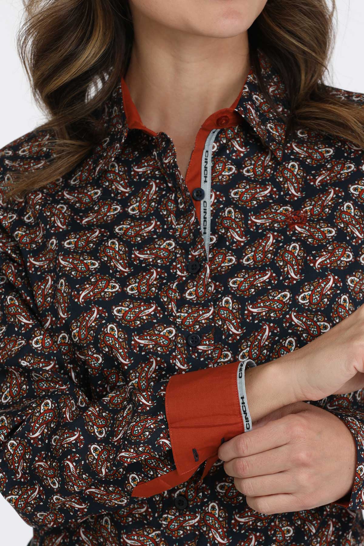 Close-up of a woman wearing a long sleeve button-down with contrasting cuffs