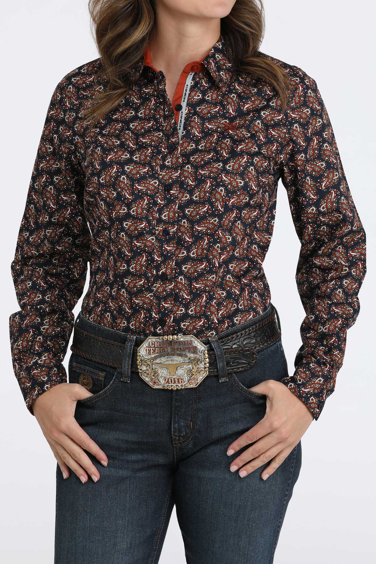Woman wearing a long sleeve button-down with a belt and jeans