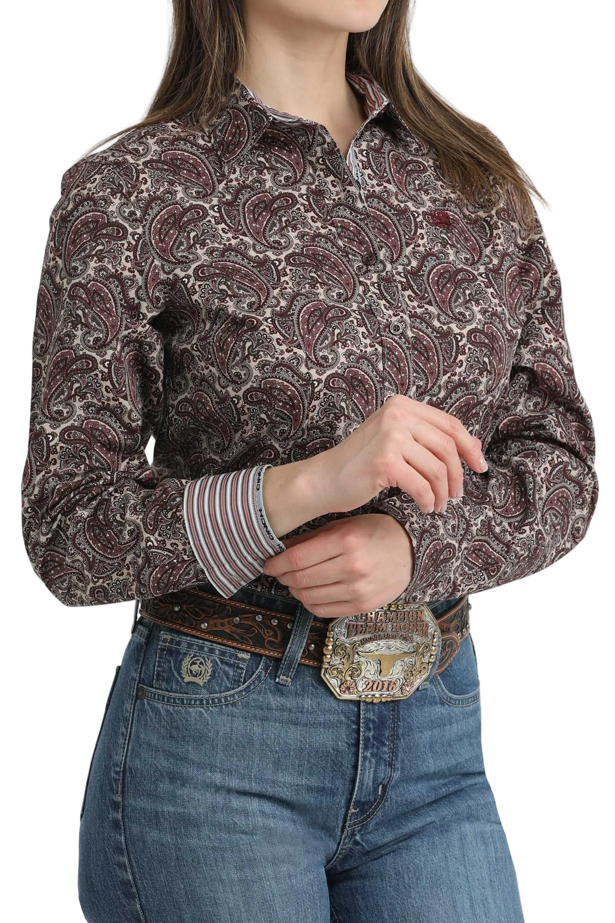 Person wearing a patterned long-sleeve shirt and jeans with a belt buckle.