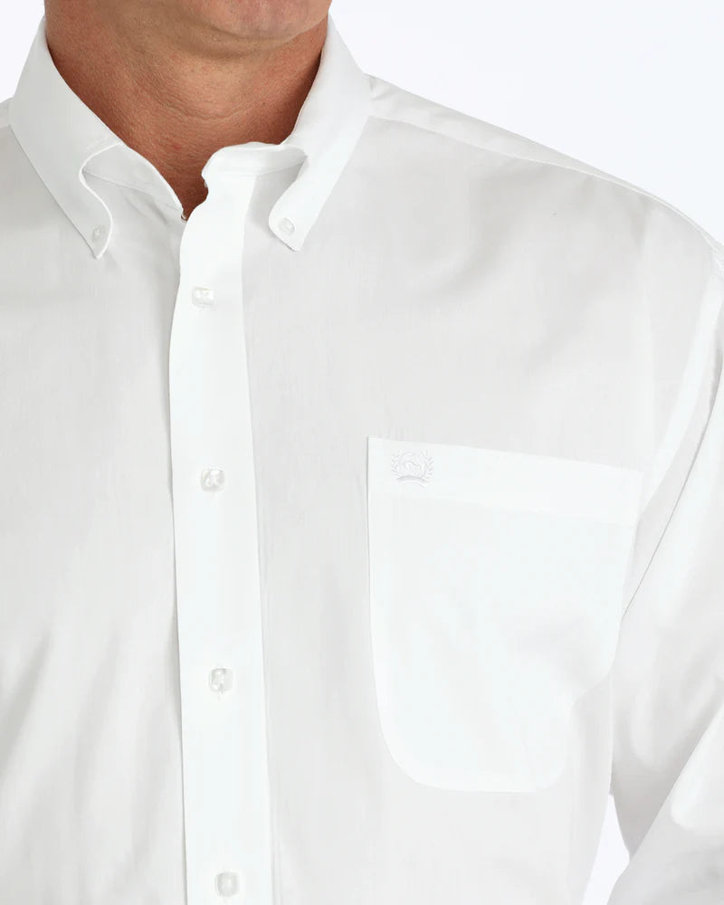 A close-up of a man wearing a white button-up shirt with a collar and a chest pocket on the left side