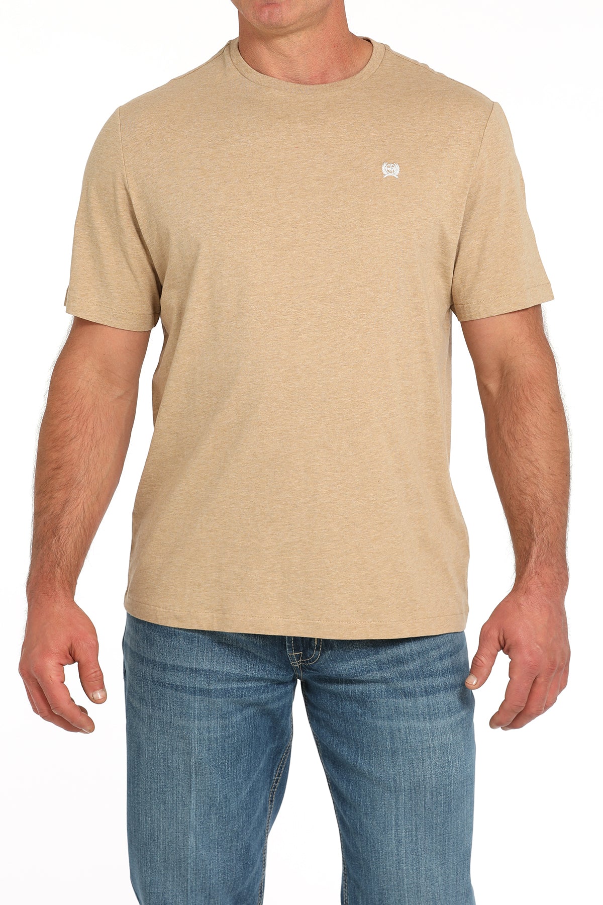 Man wearing a light tan t-shirt and blue jeans on a white background