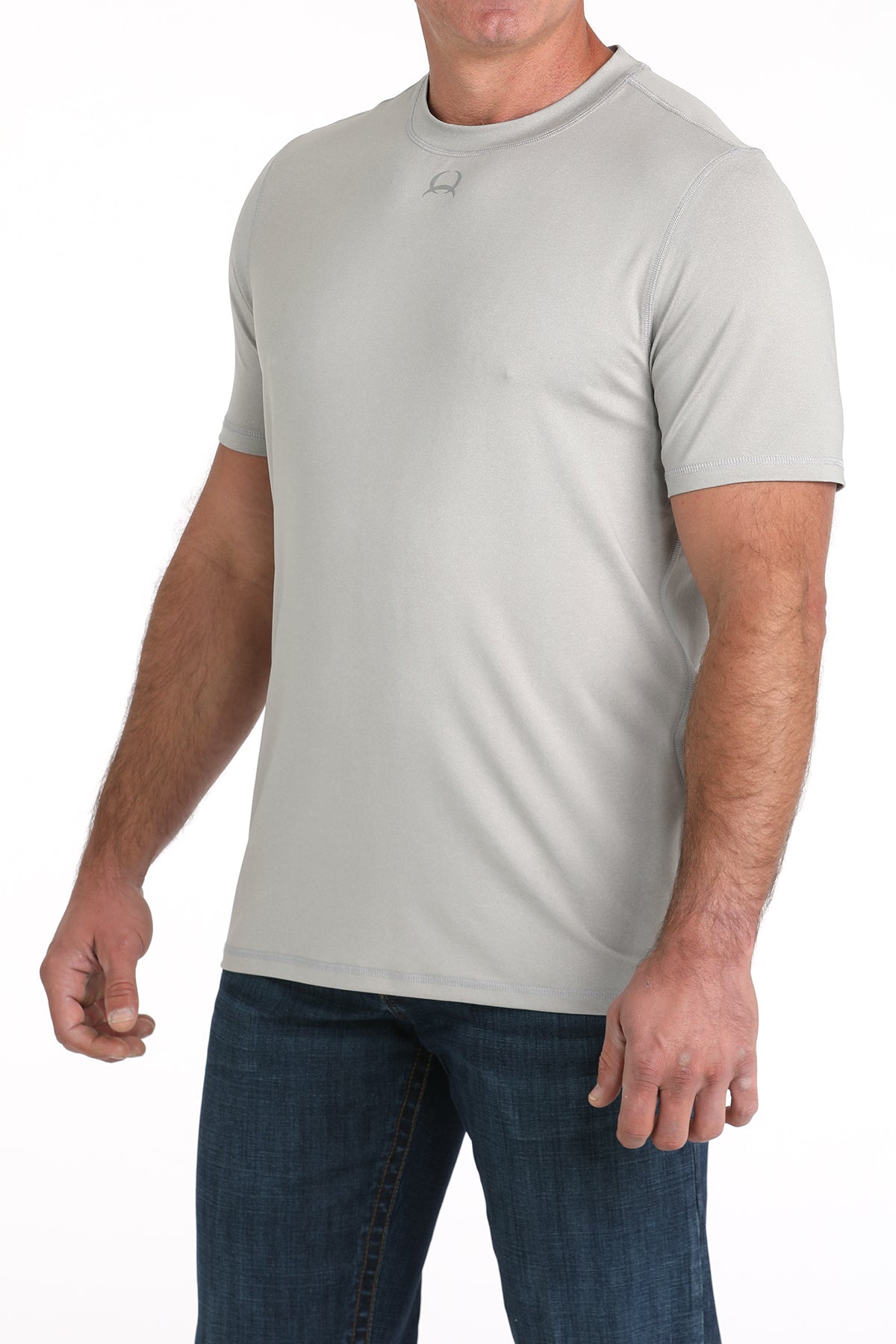 Man wearing a light gray t-shirt and blue jeans on a white background