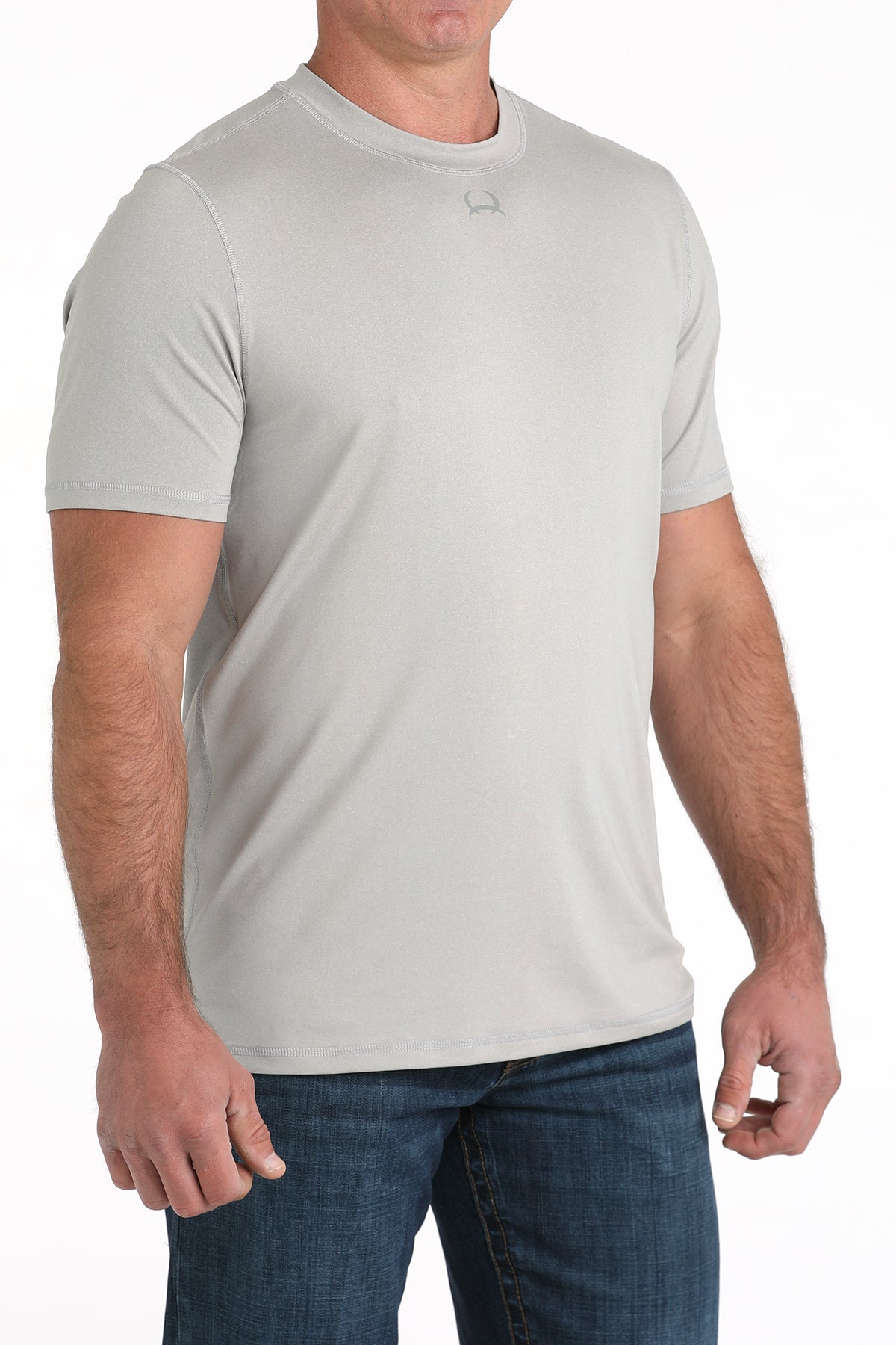 Man wearing a light gray t-shirt and blue jeans on a white background