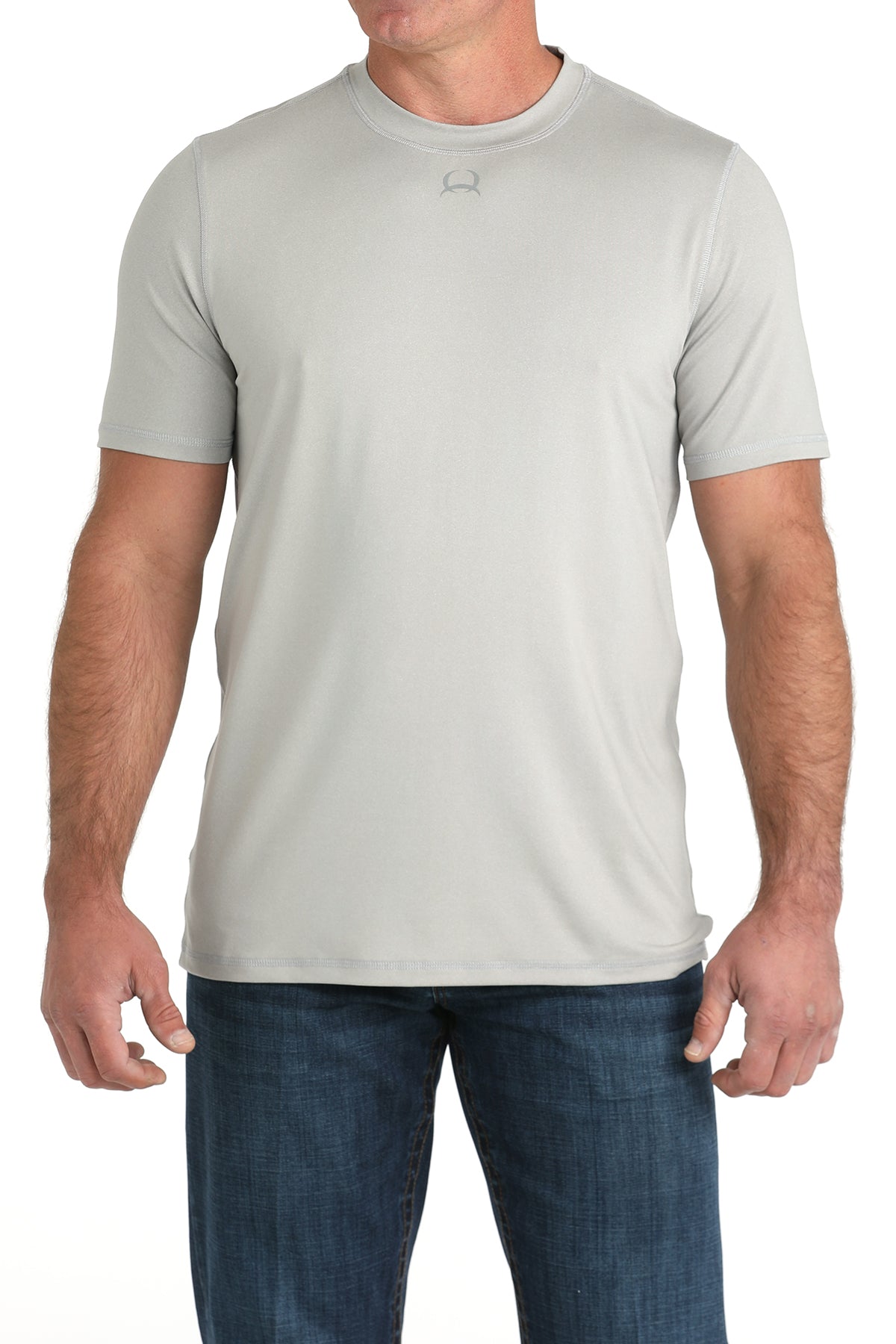 Man wearing a light gray t-shirt and blue jeans on a white background