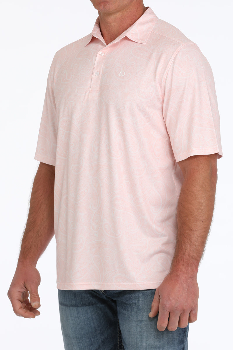Man wearing a light pink, short sleeve, collared shirt and jeans