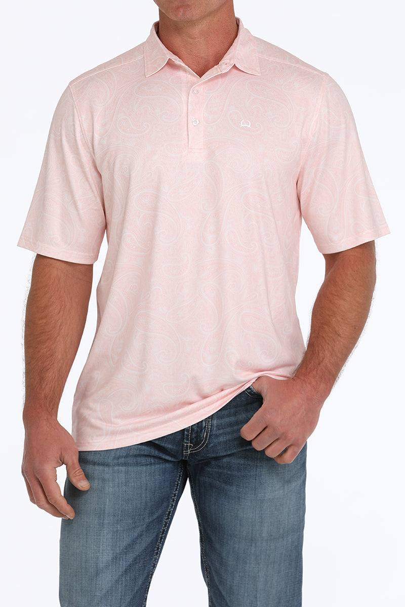 Man wearing a light pink, short sleeve, collared shirt and jeans