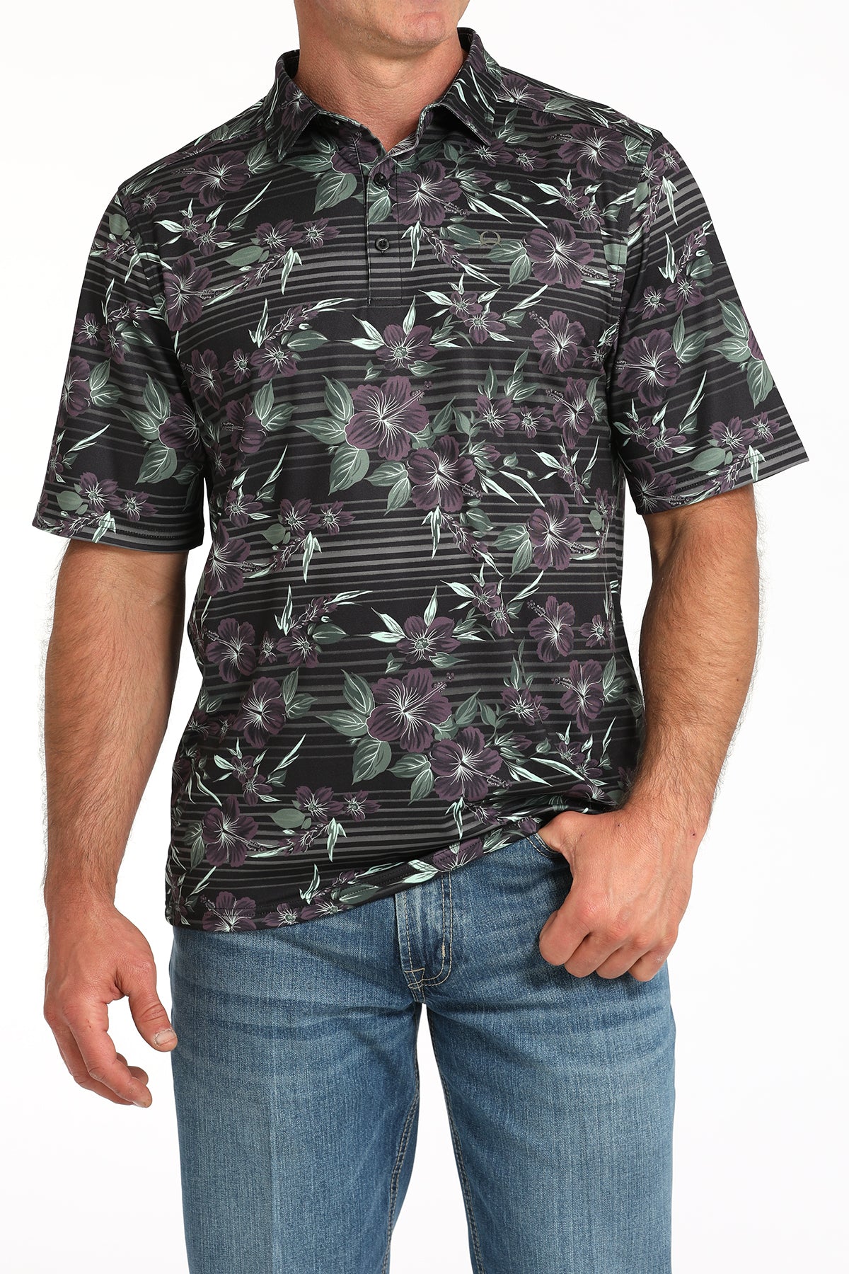 Man wearing a black floral patterned shirt with blue jeans on a white background