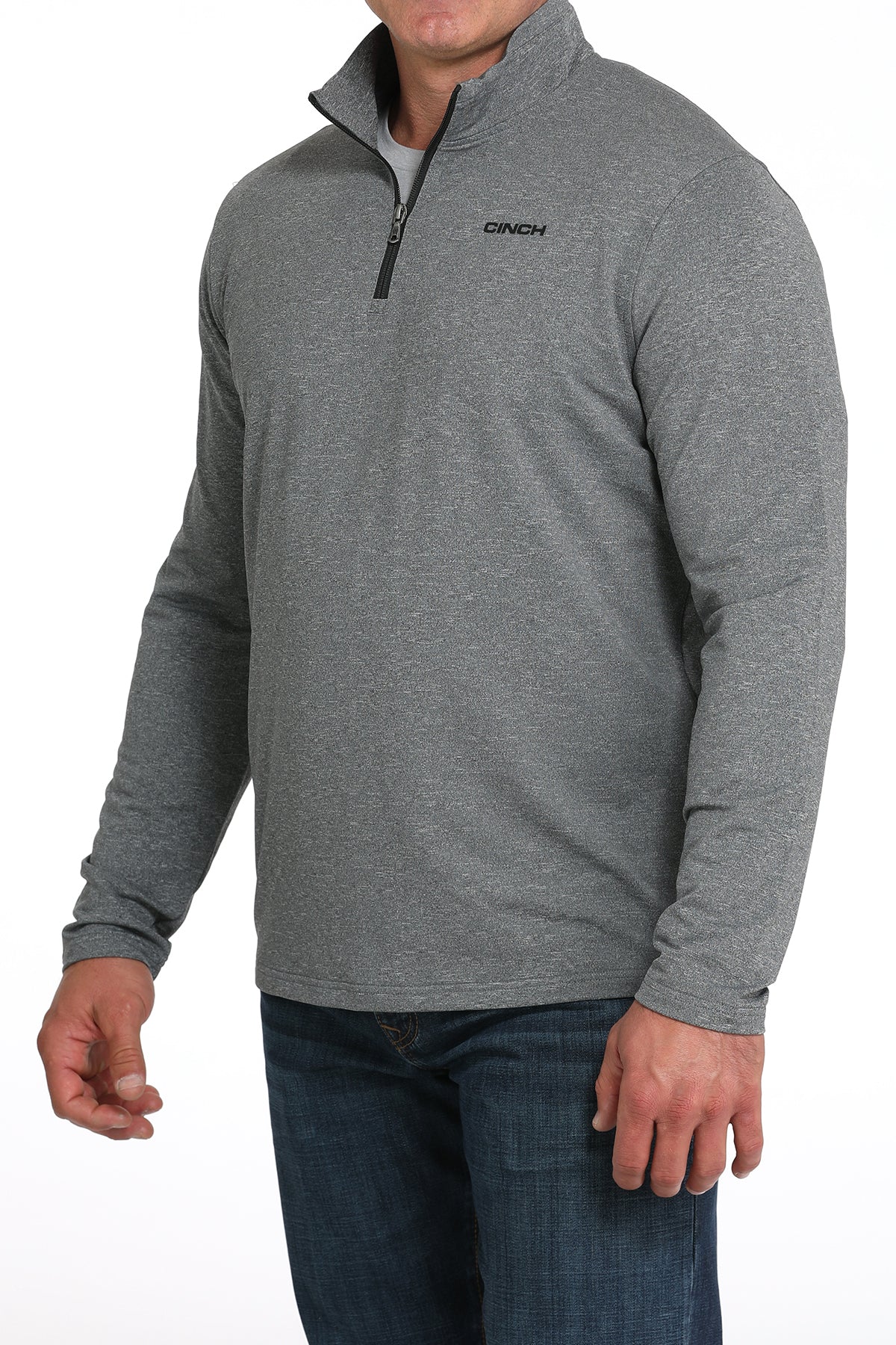 Man wearing a gray long-sleeve shirt with a quarter zip and blue jeans on a white background