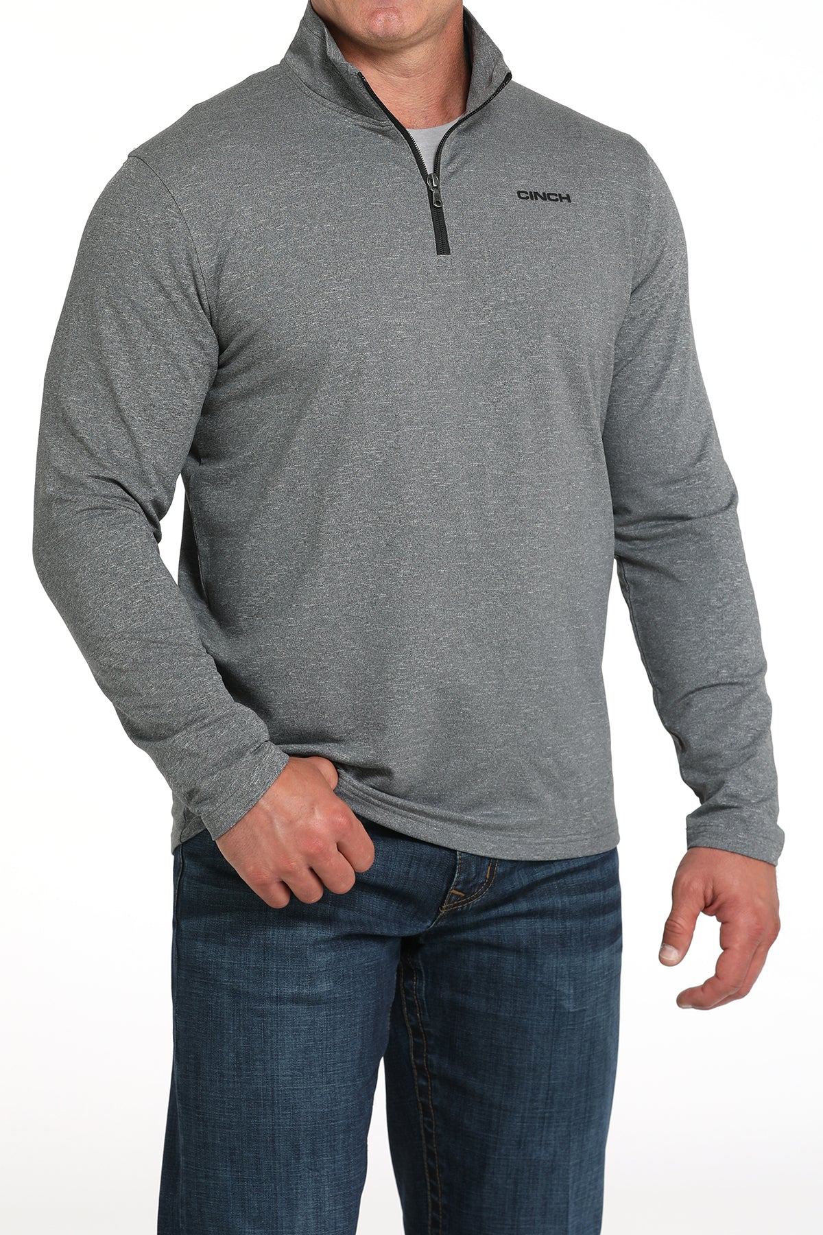 Man wearing a gray long-sleeve shirt with a quarter zip and blue jeans on a white background