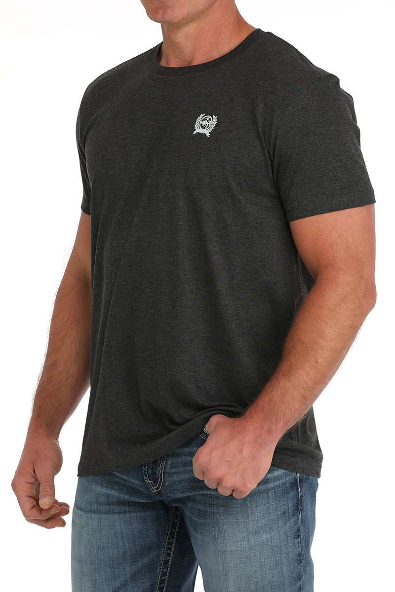 Man wearing a dark gray t-shirt and blue jeans on a white background
