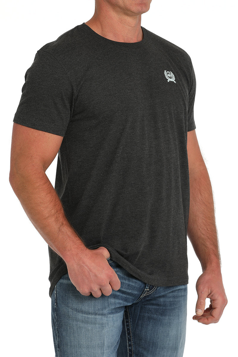 Man wearing a dark gray t-shirt and blue jeans on a white background