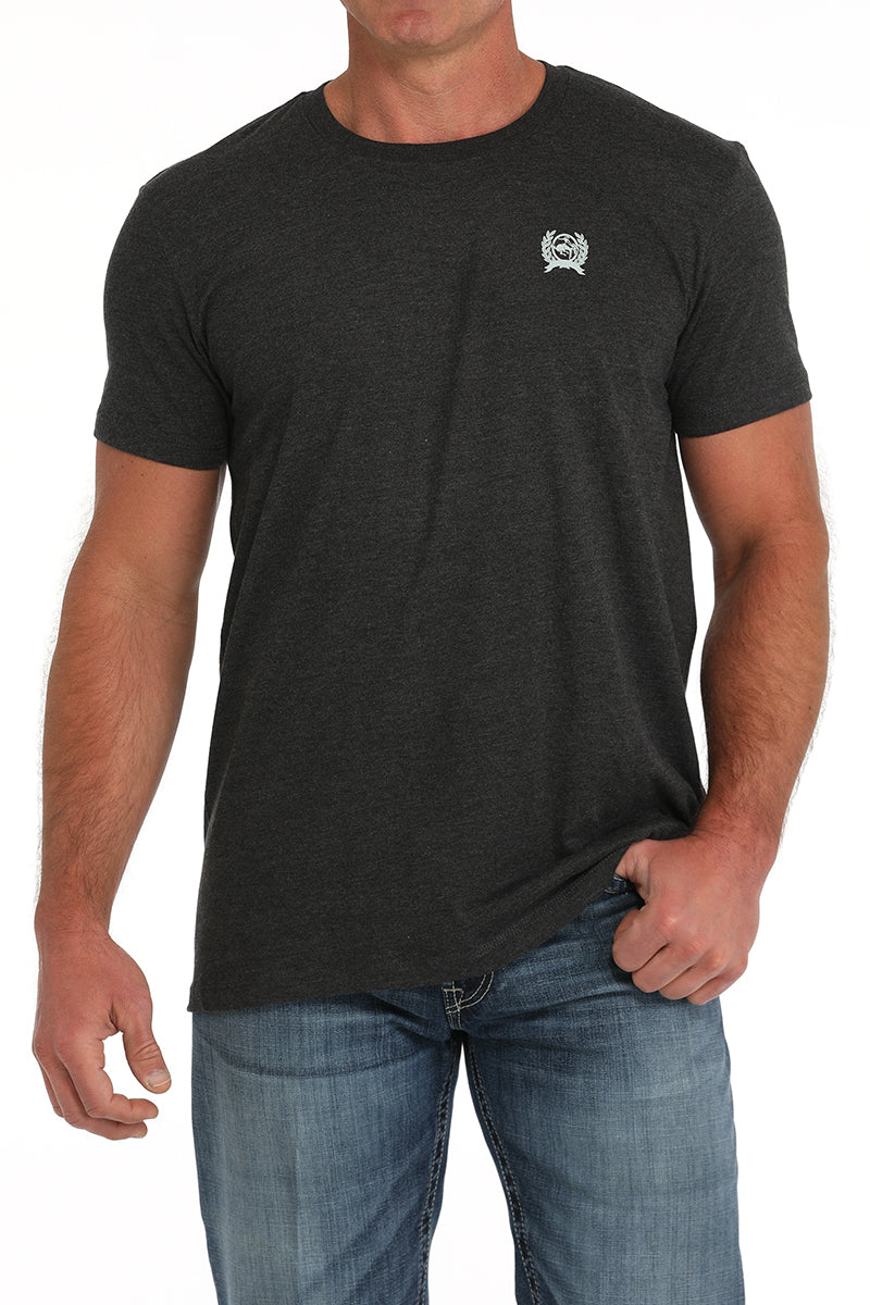 Man wearing a dark gray t-shirt and blue jeans on a white background