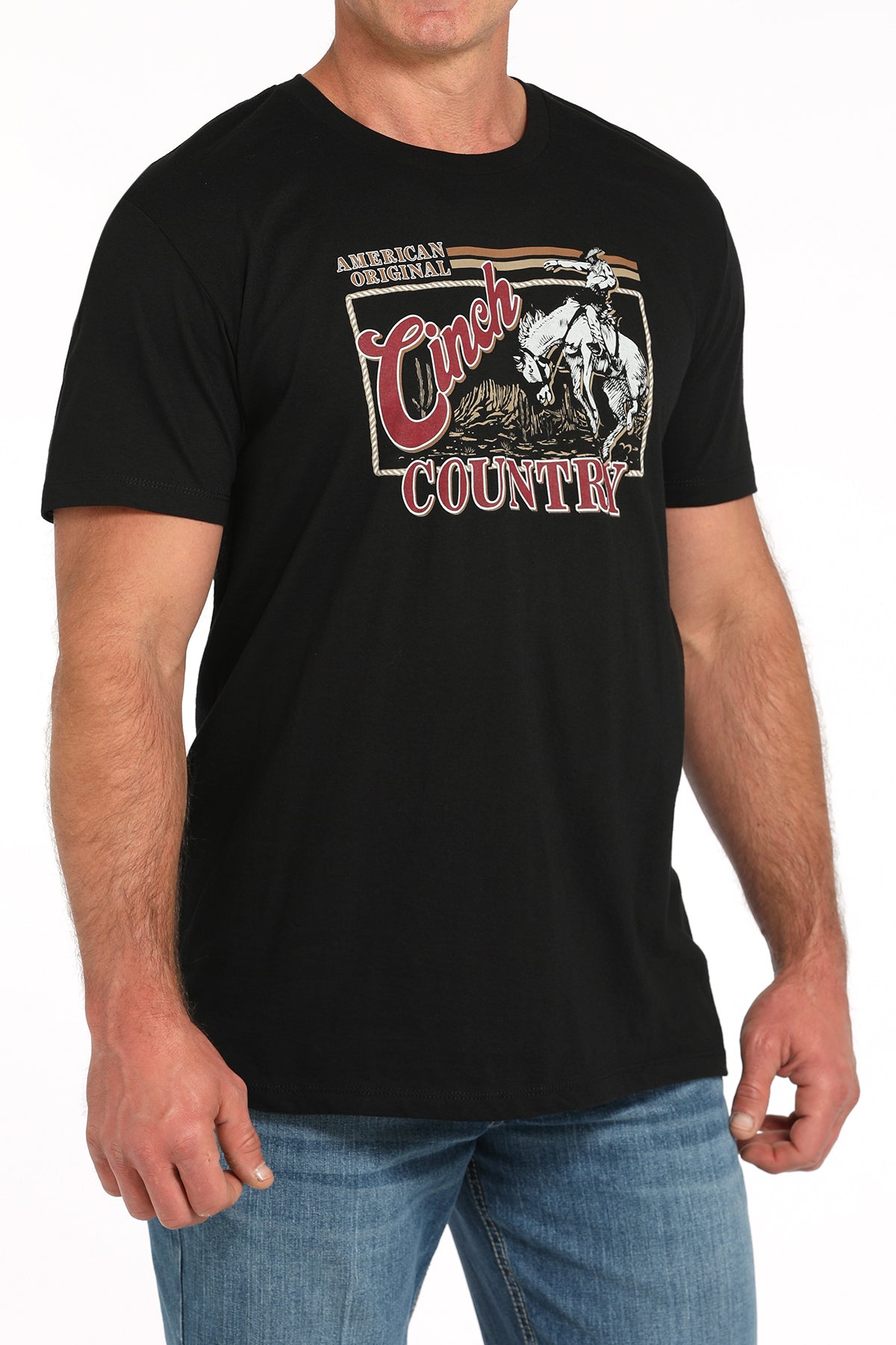 Man wearing a black t-shirt with a large 'Cinch' graphic on the front and blue jeans on a white background