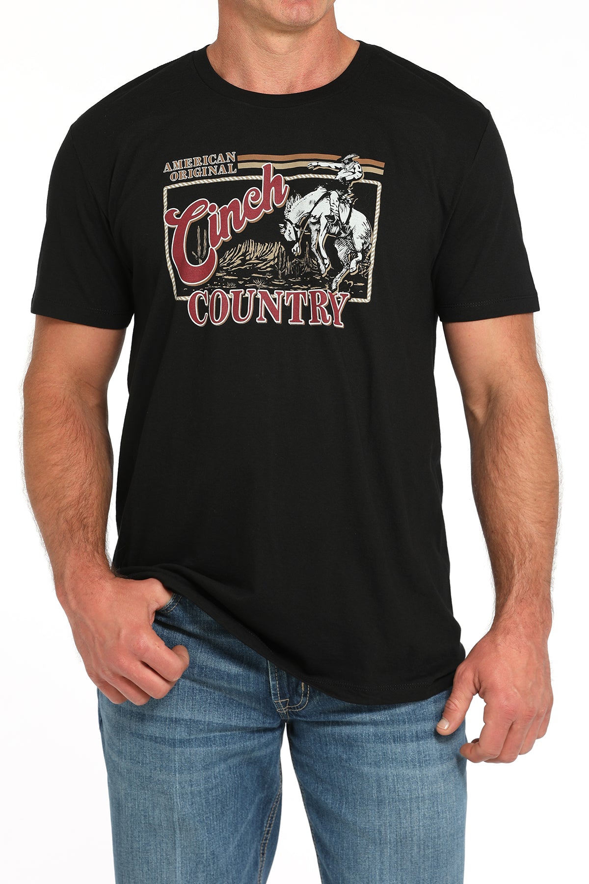 Man wearing a black t-shirt with a large 'Cinch' graphic on the front and blue jeans on a white background