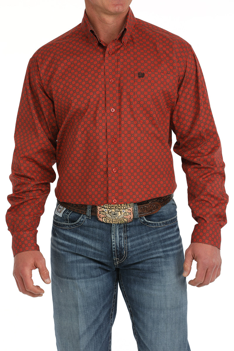 Man wearing a red, long sleeve, patterned, button-down, paired with jeans and a belt