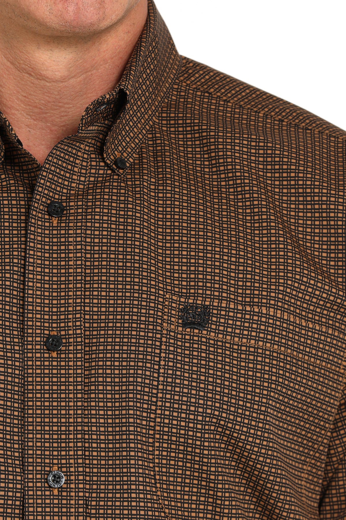 Close-up of a man wearing a brown long sleeve button-down shirt