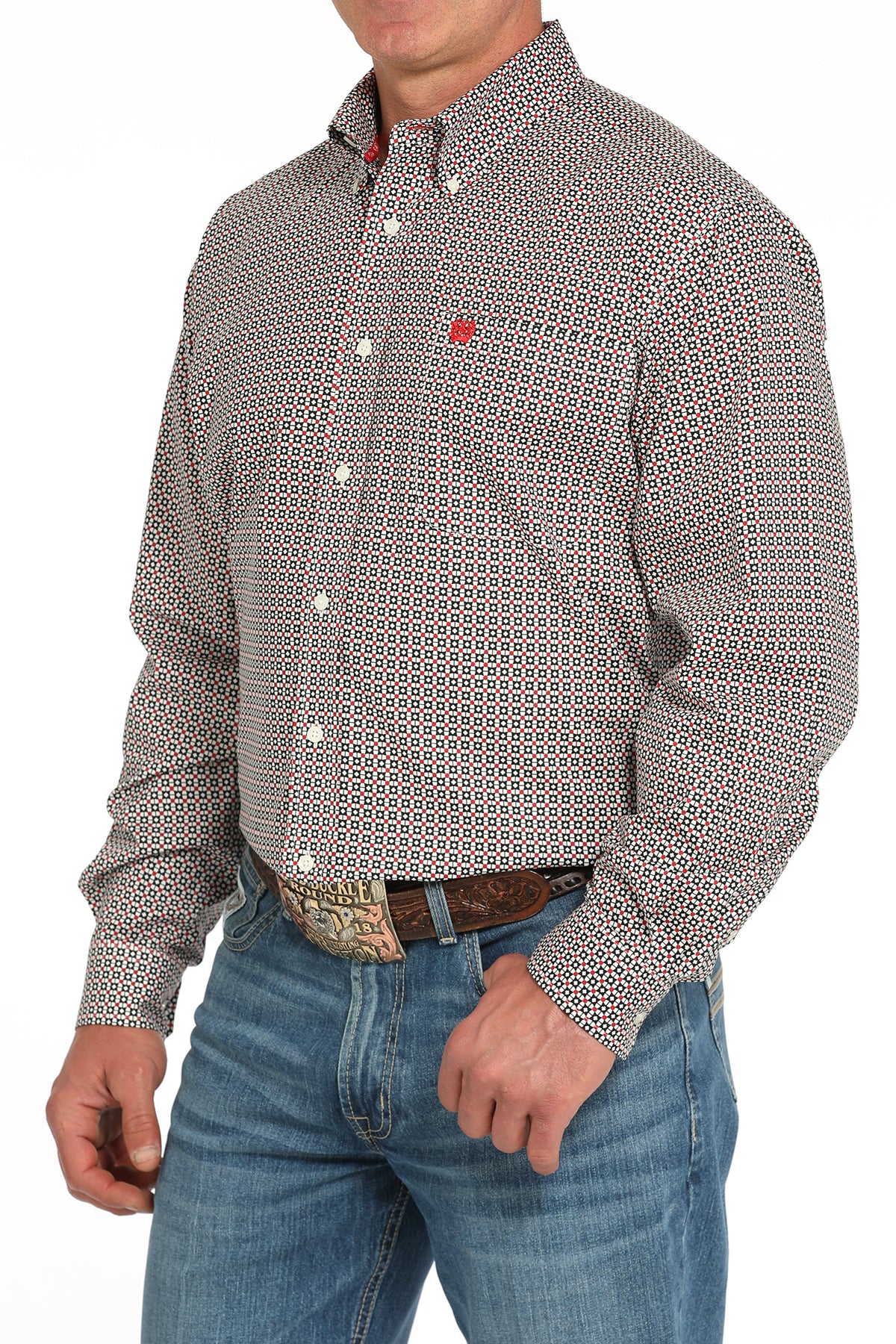 Man wearing a patterned long sleeve button-down shirt with jeans and a belt