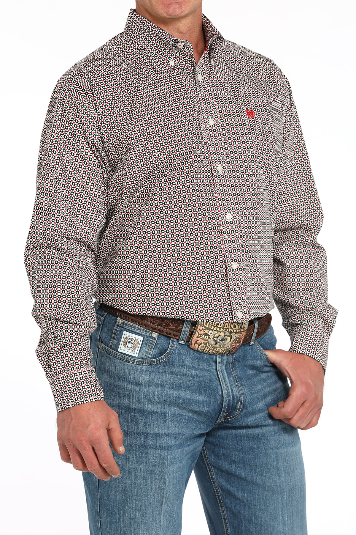 Man wearing a patterned long sleeve button-down shirt with jeans and a belt