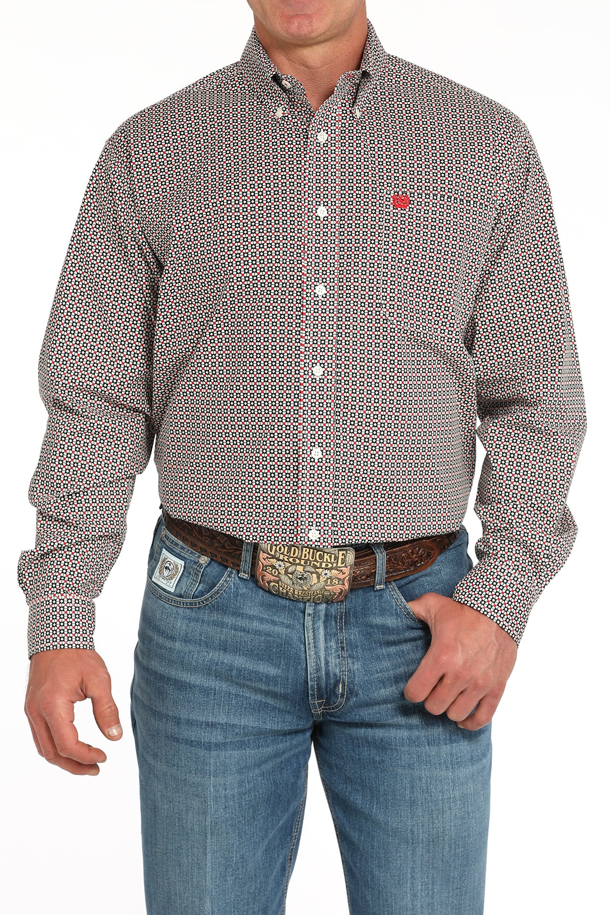 Man wearing a patterned long sleeve button-down shirt with jeans and a belt