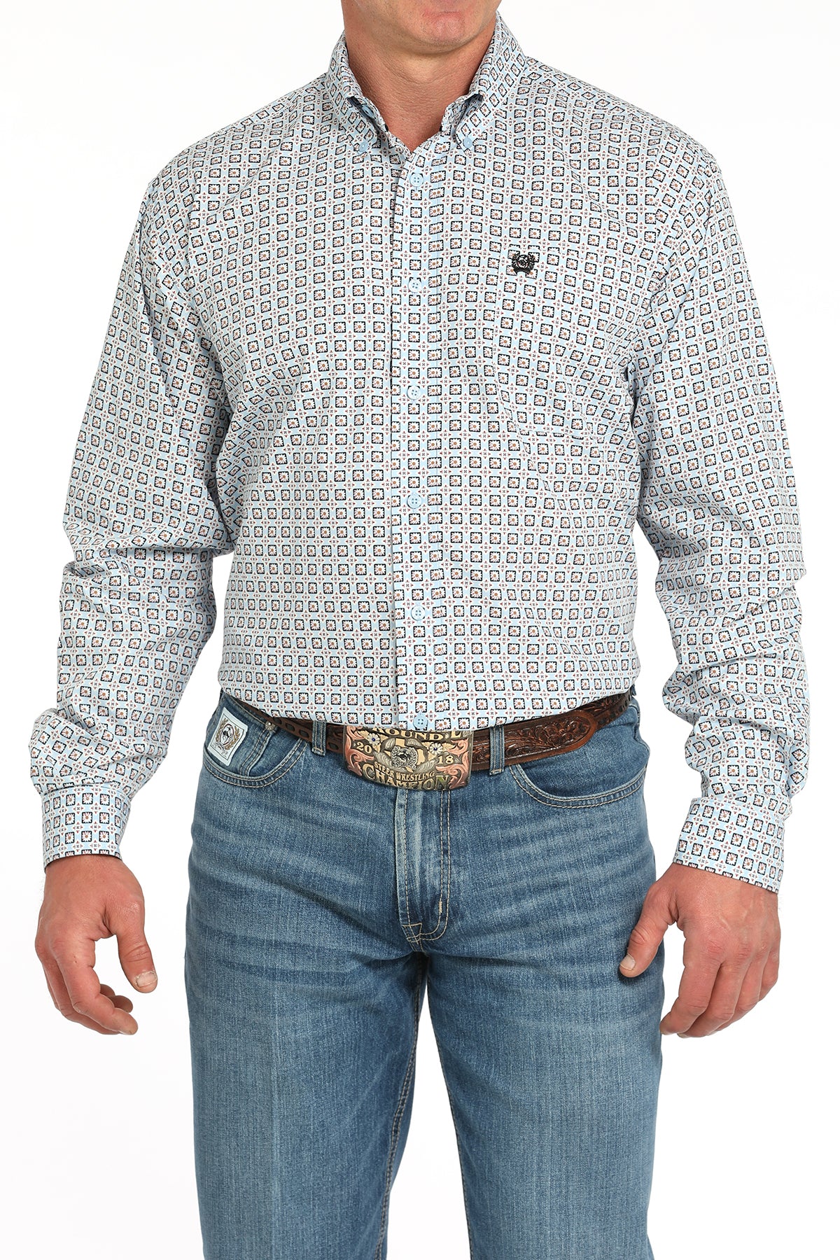 Man wearing a patterned long sleeve button-down shirt with jeans and a belt