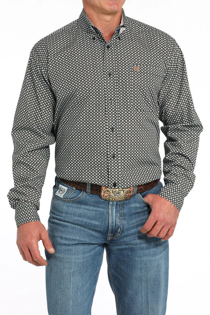 Man wearing a black geometric print Cinch long sleeve button-down shirt with jeans and a belt buckle on a white background