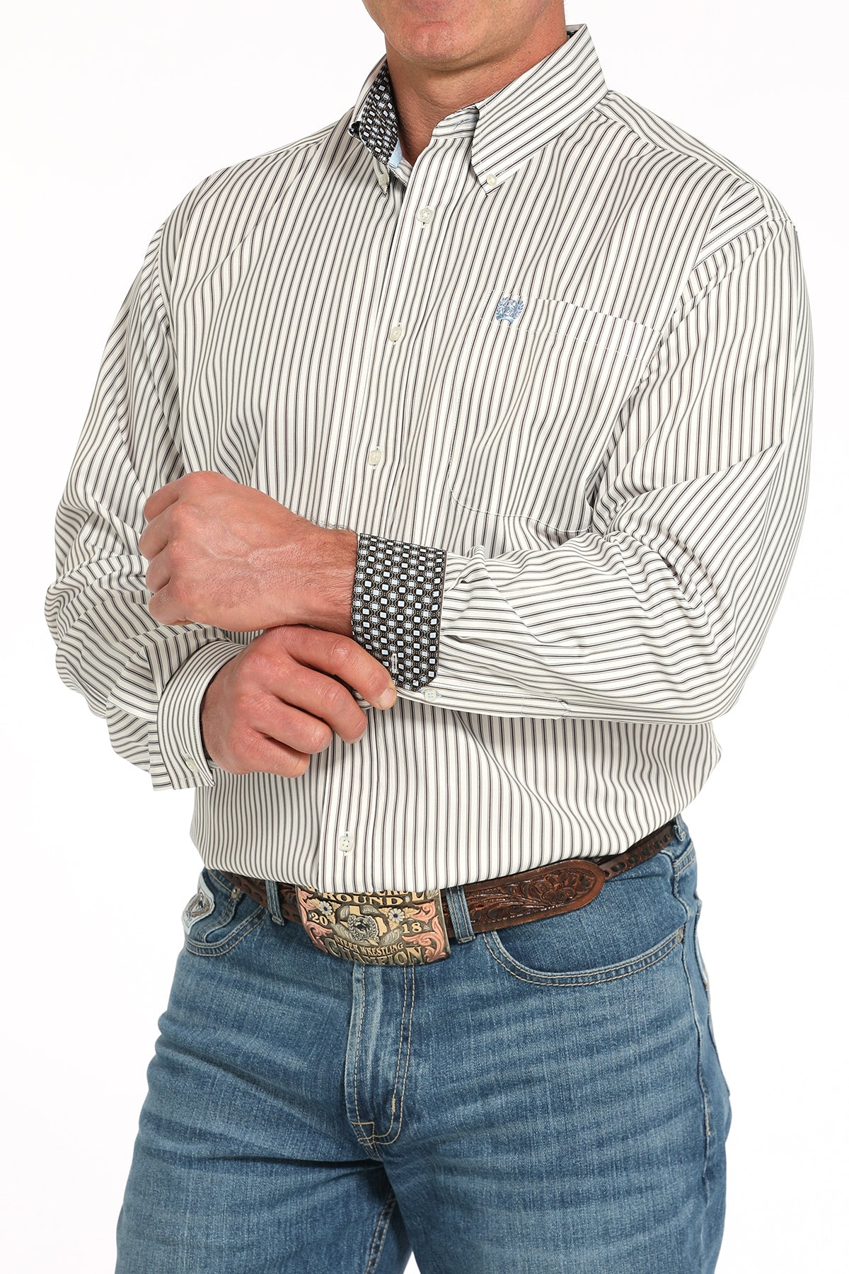 Man wearing a striped shirt and jeans with a belt buckle.