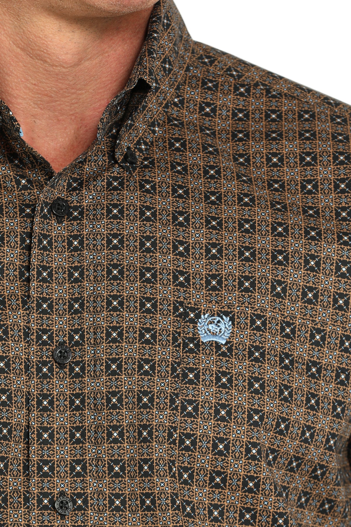 Close-up of a man wearing a brown long sleeve button-down shirt