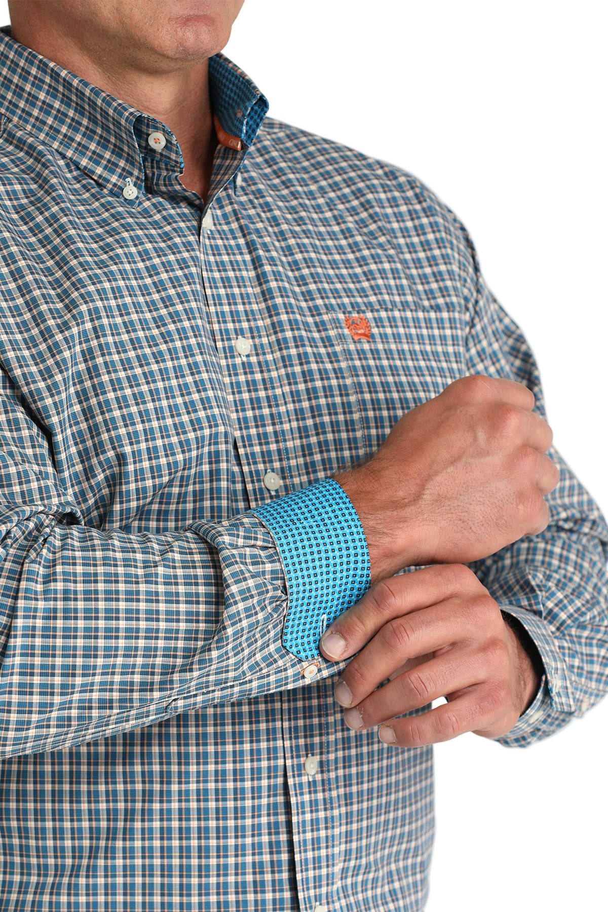 Close-up of a man wearing a patterned blue long sleeve button-down shirt with contrasting cuffs on a transparent background