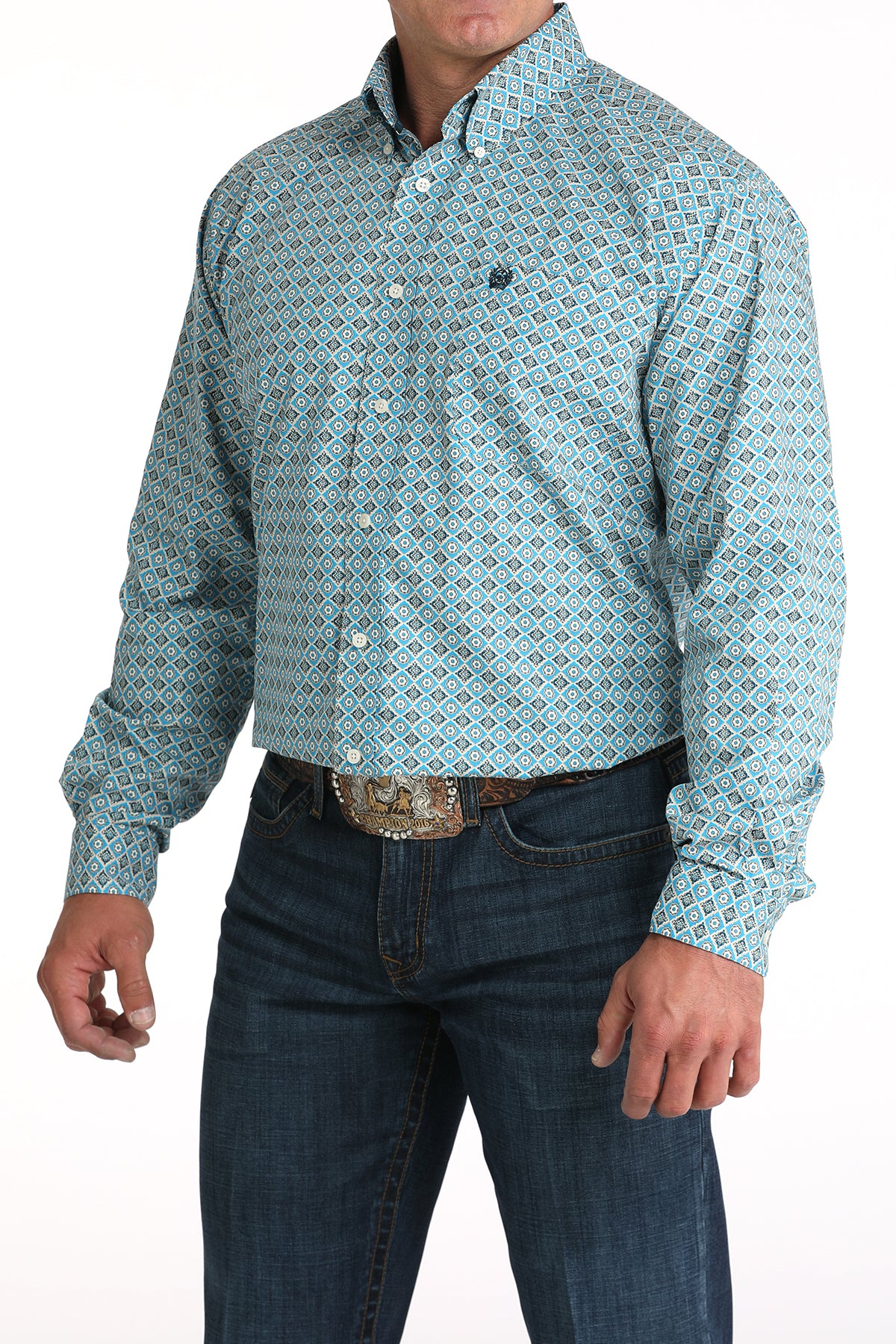 Man wearing a patterned teal shirt and jeans on a white background