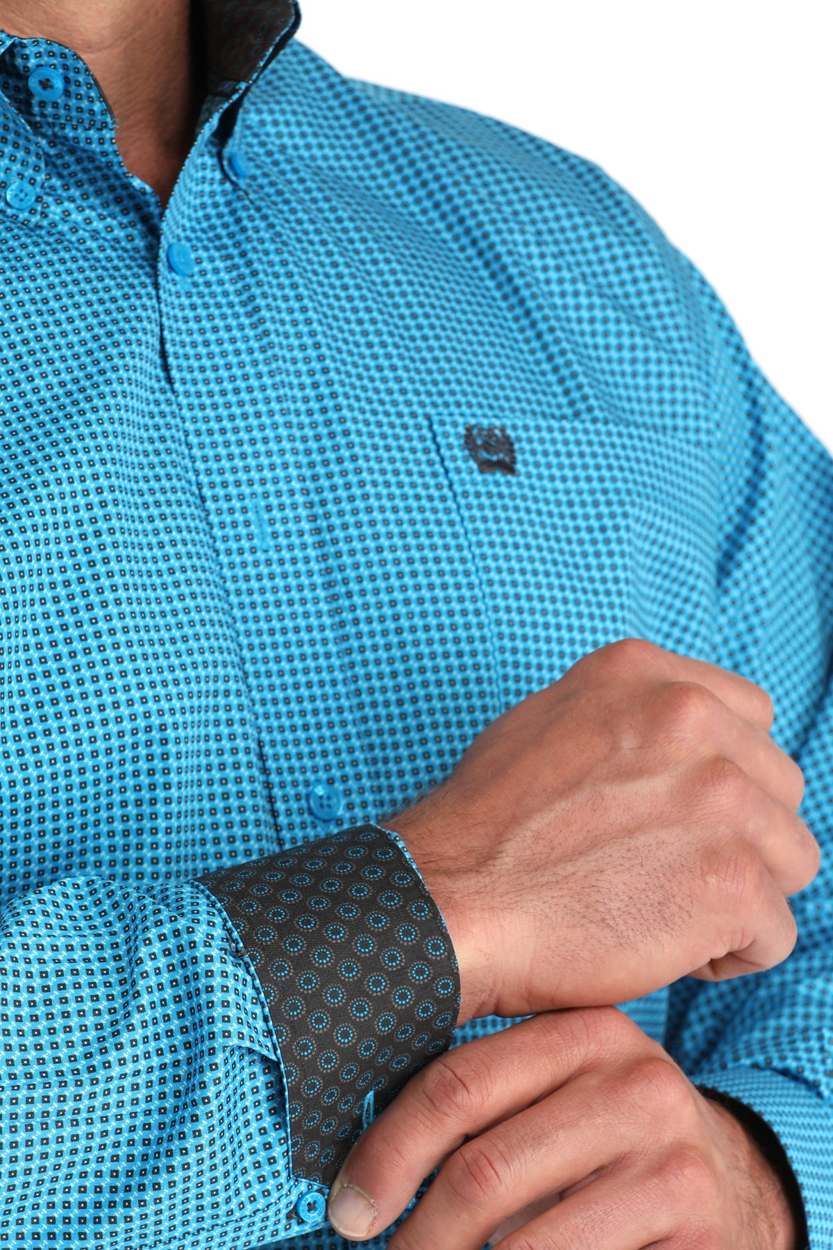 Close-up of a person wearing a blue checkered shirt with a brand logo.