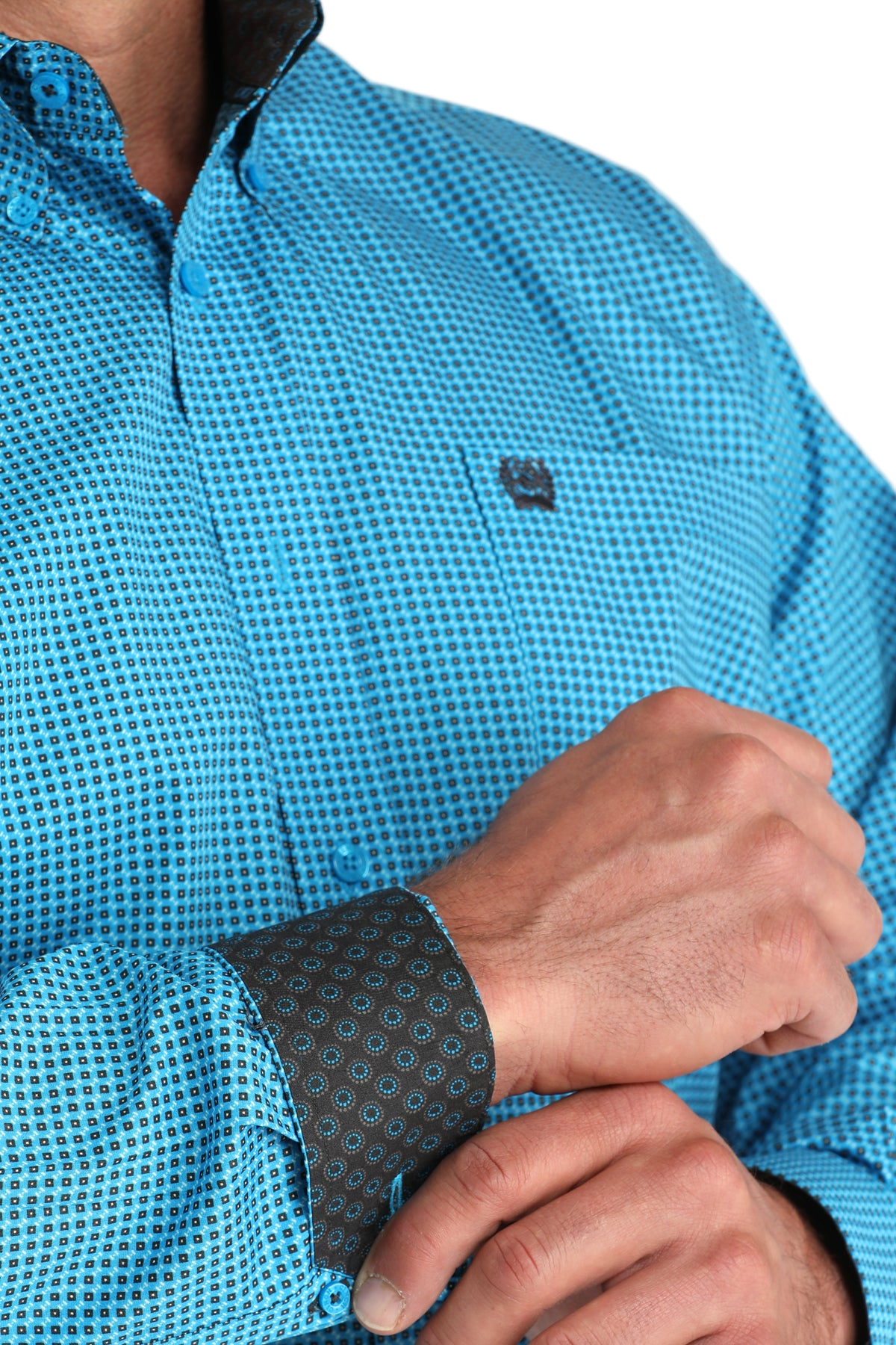 Close-up of a man wearing a patterned blue long sleeve button-down shirt with contrasting cuffs on a transparent background