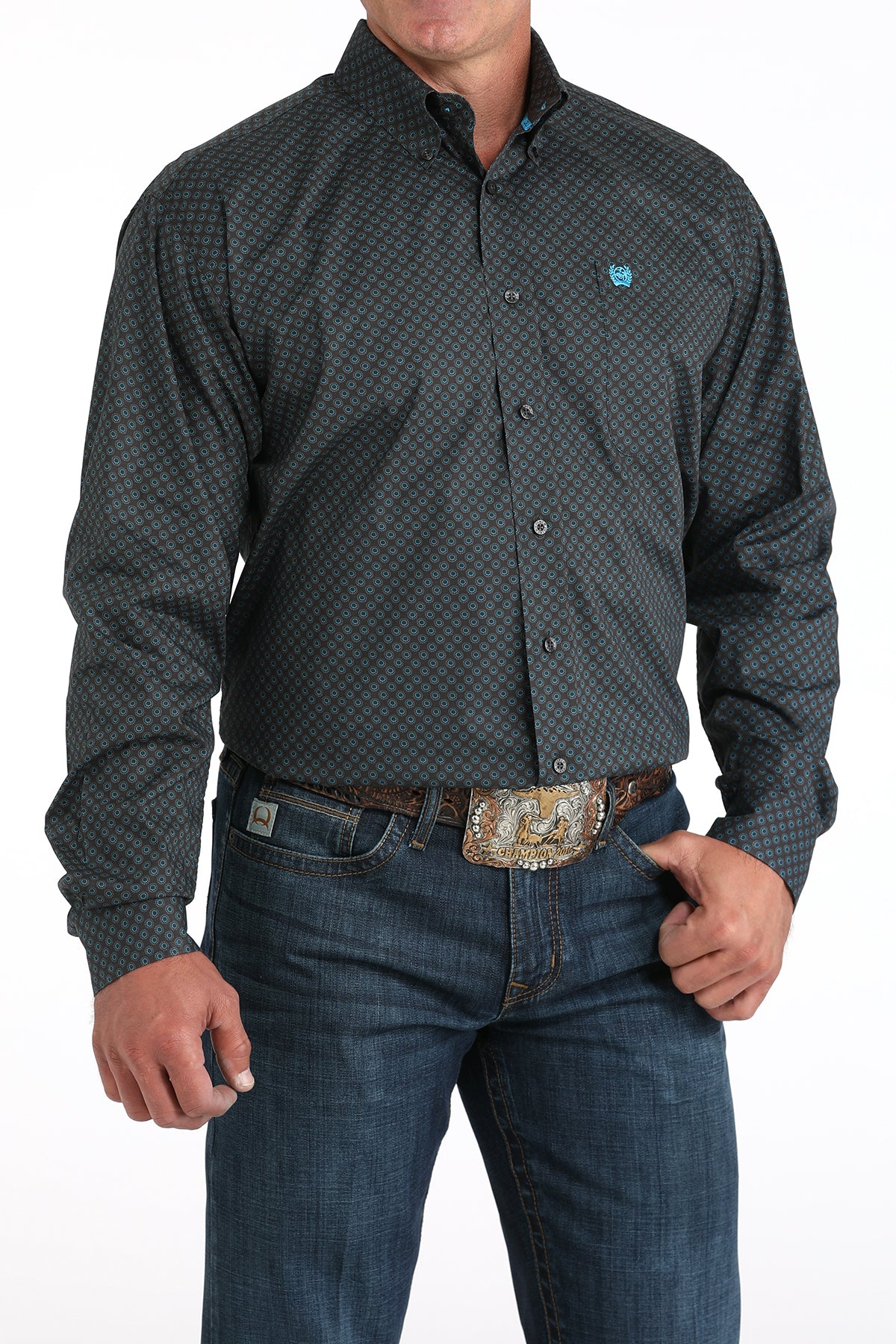 Man wearing a patterned gray shirt and jeans on a white background