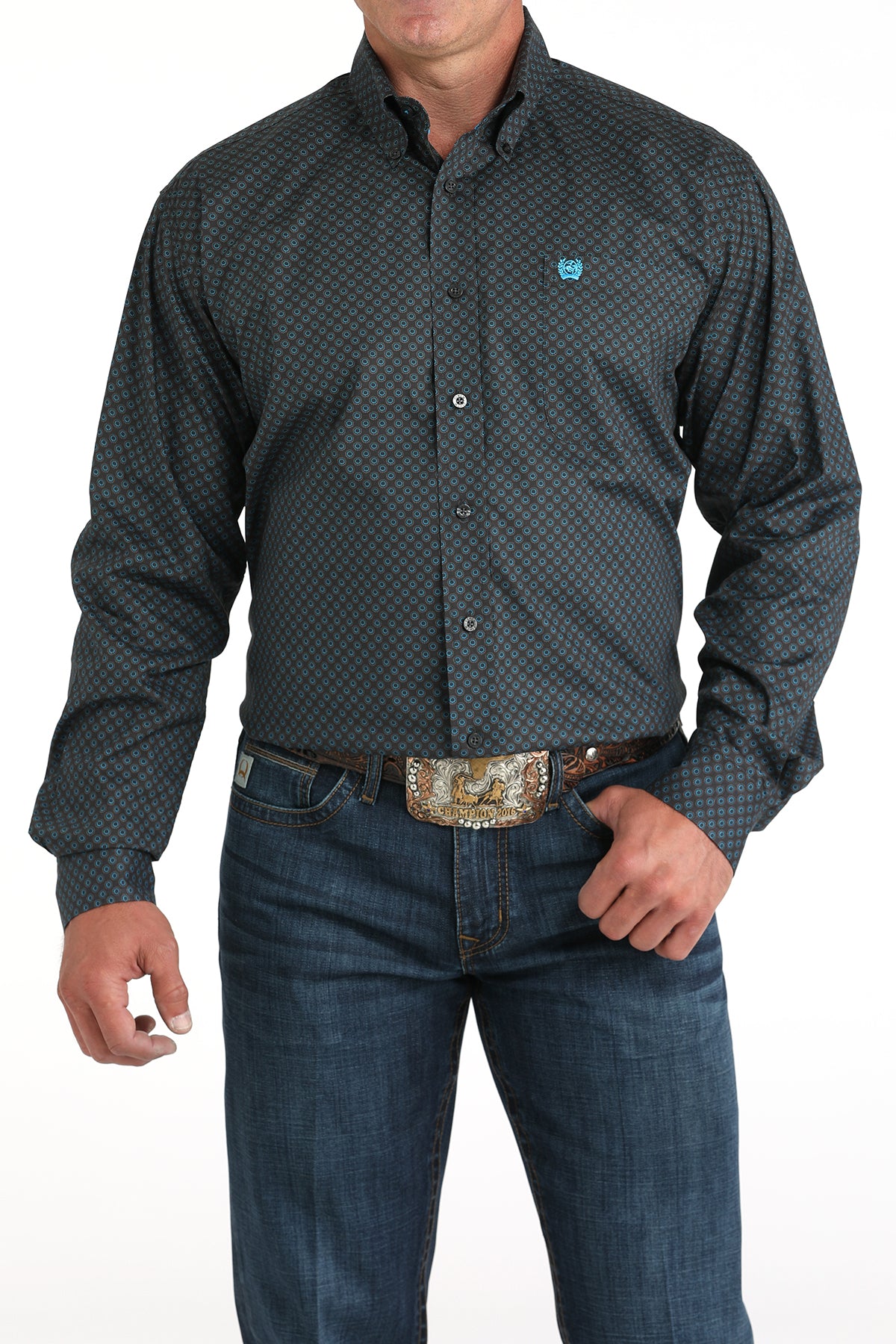Man wearing a patterned dark shirt and jeans on a white background