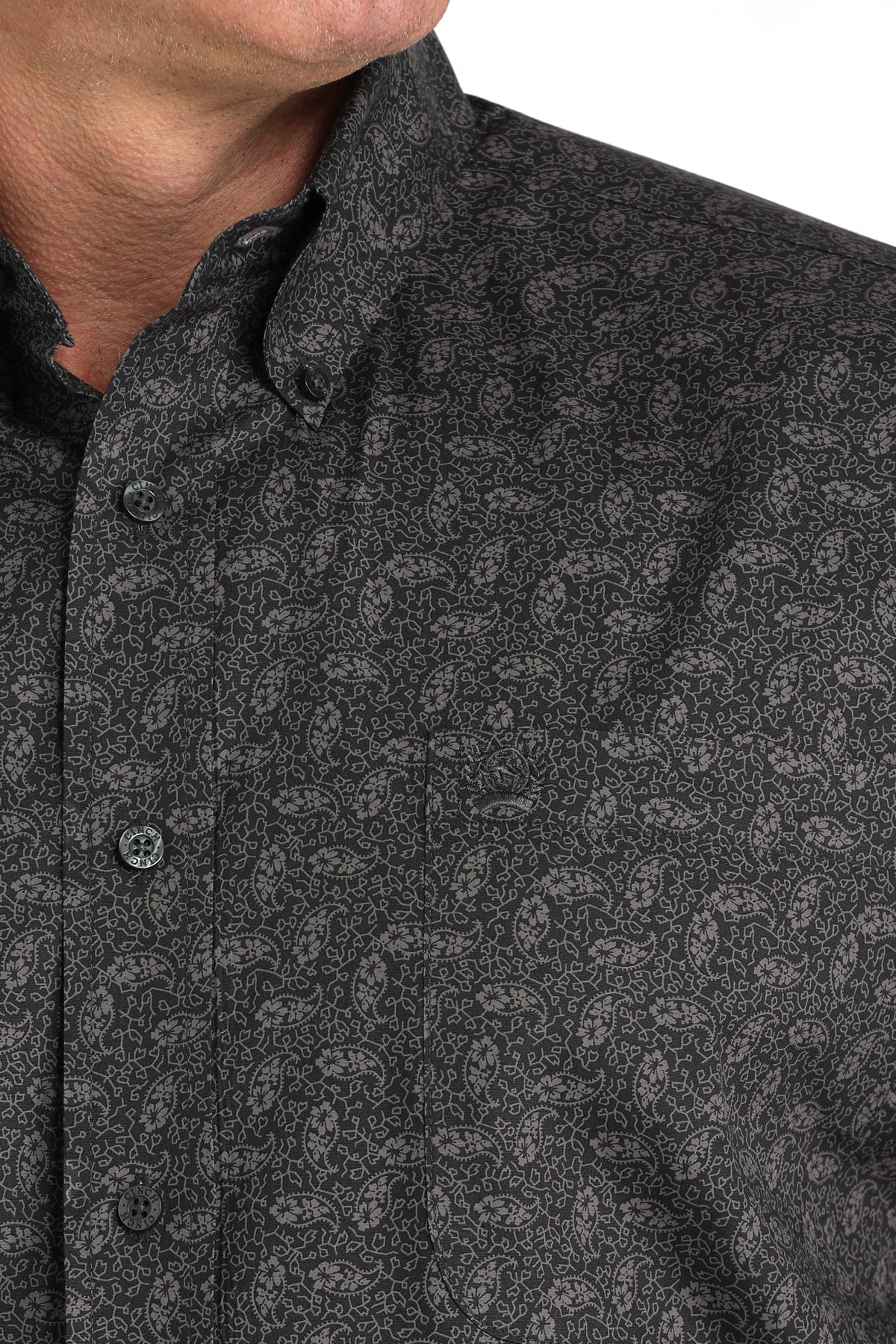 Close-up of a man wearing a dark gray long sleeve button-down shirt
