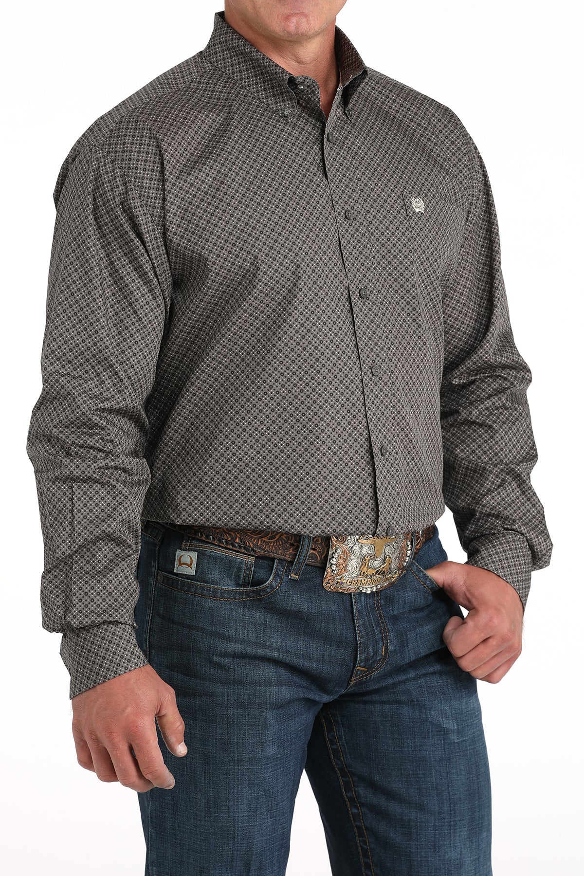 Man wearing a patterned shirt and jeans on a white background