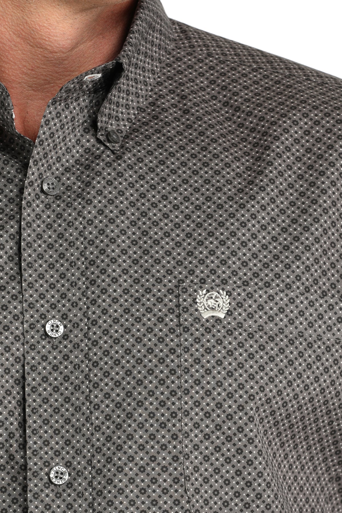 Close-up of a patterned shirt with a small logo on a white background