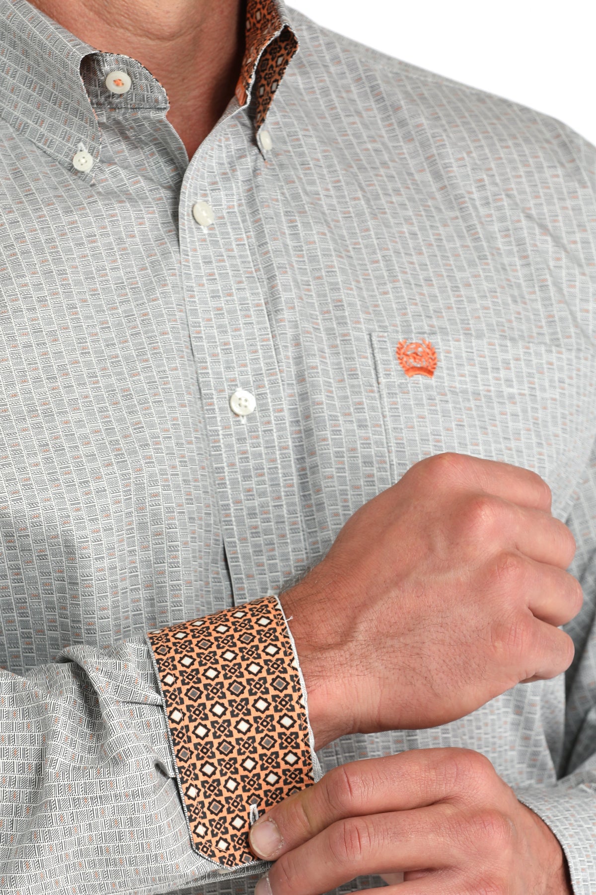 Close-up of a person wearing a patterned shirt with a visible brand logo.