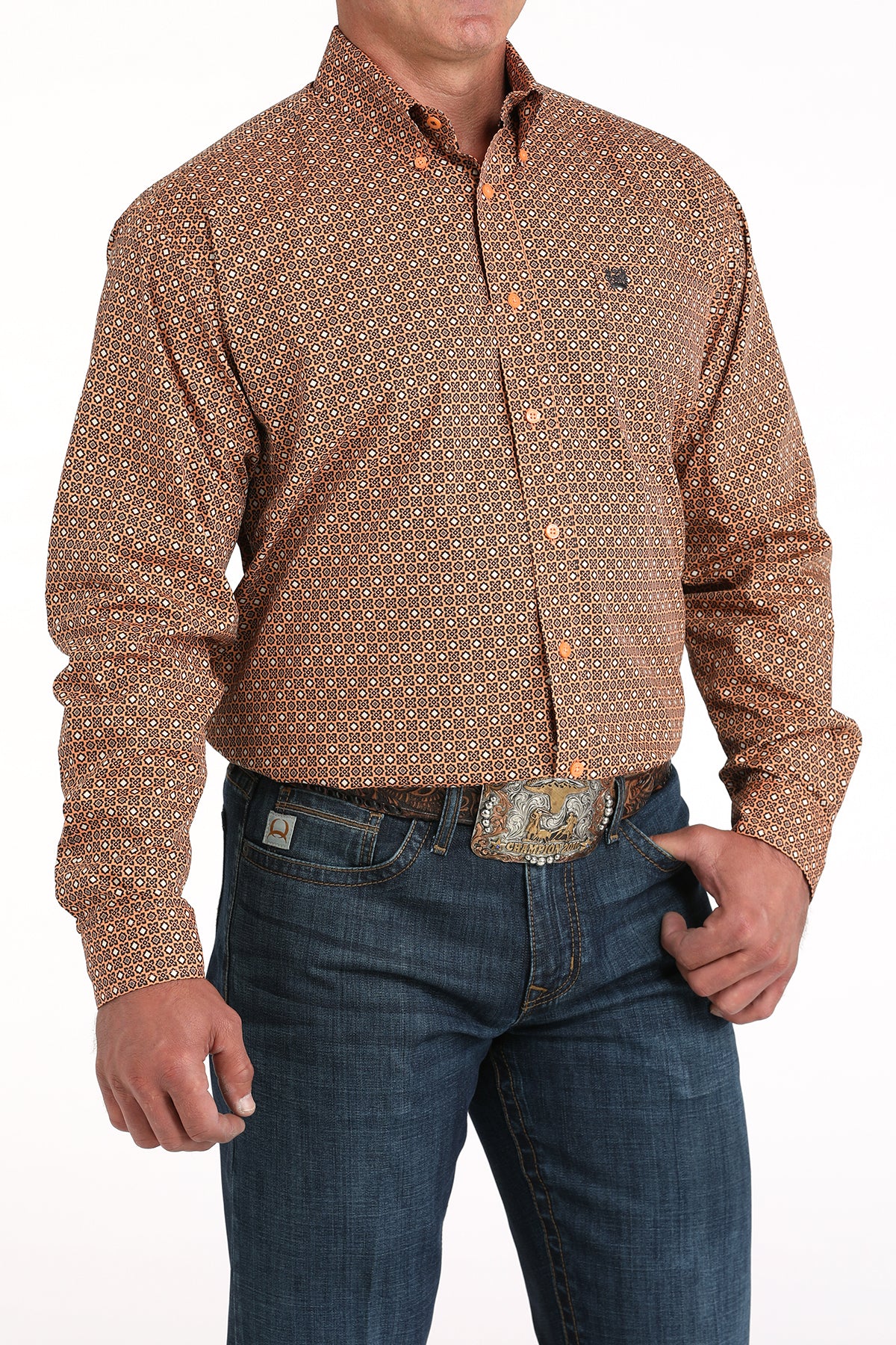 Man wearing a patterned brown shirt and blue jeans on a white background