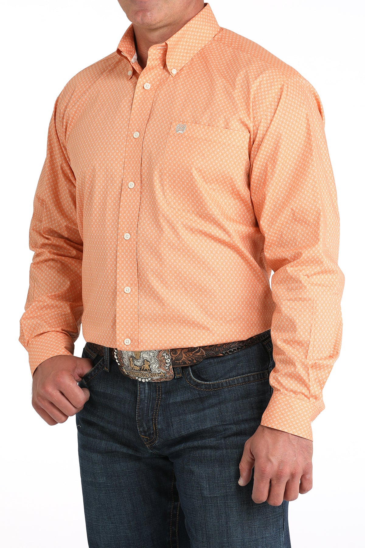Person wearing an orange patterned shirt and blue jeans on a white background