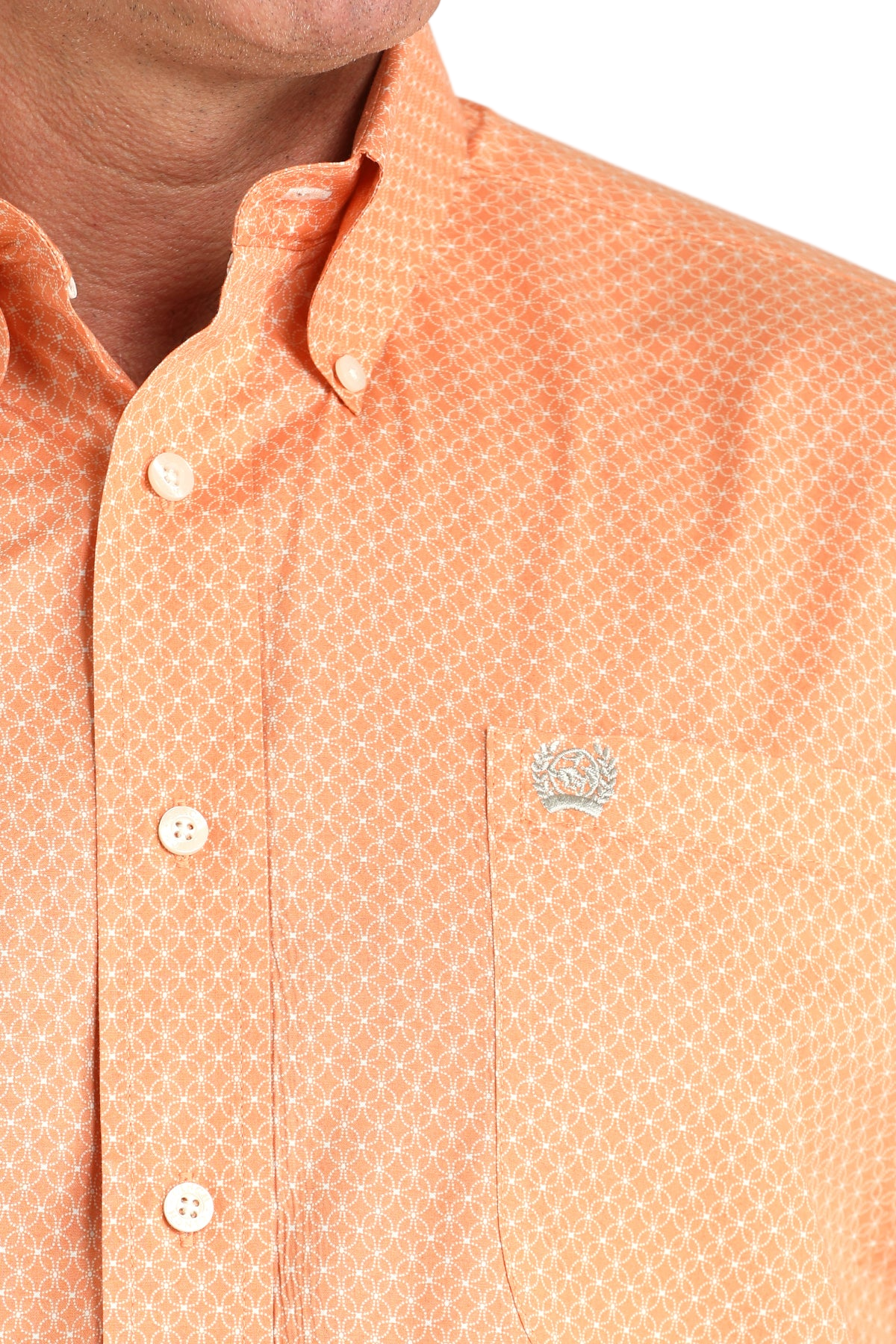 Close-up of a man wearing a patterned orange long sleeve button-down shirt on a transparent background