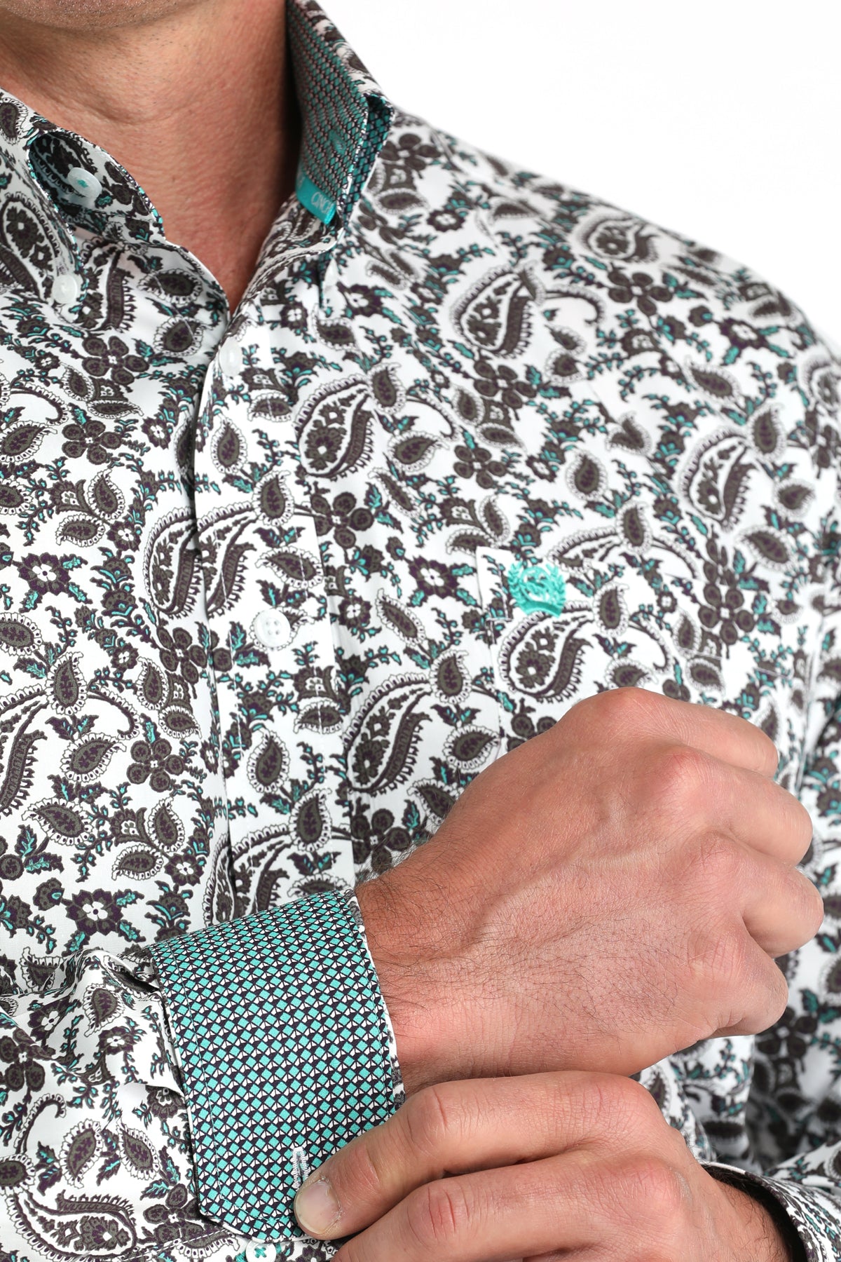 Close-up of a person wearing a patterned shirt with a turquoise tie.