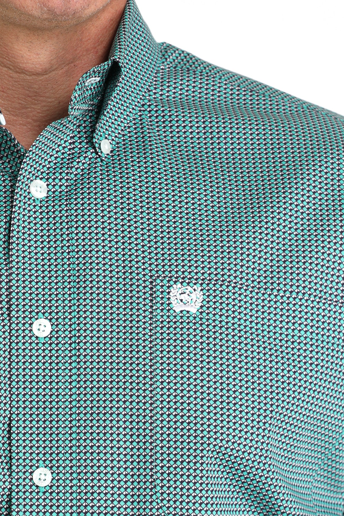 Close-up of a man wearing a teal long sleeve button-down shirt