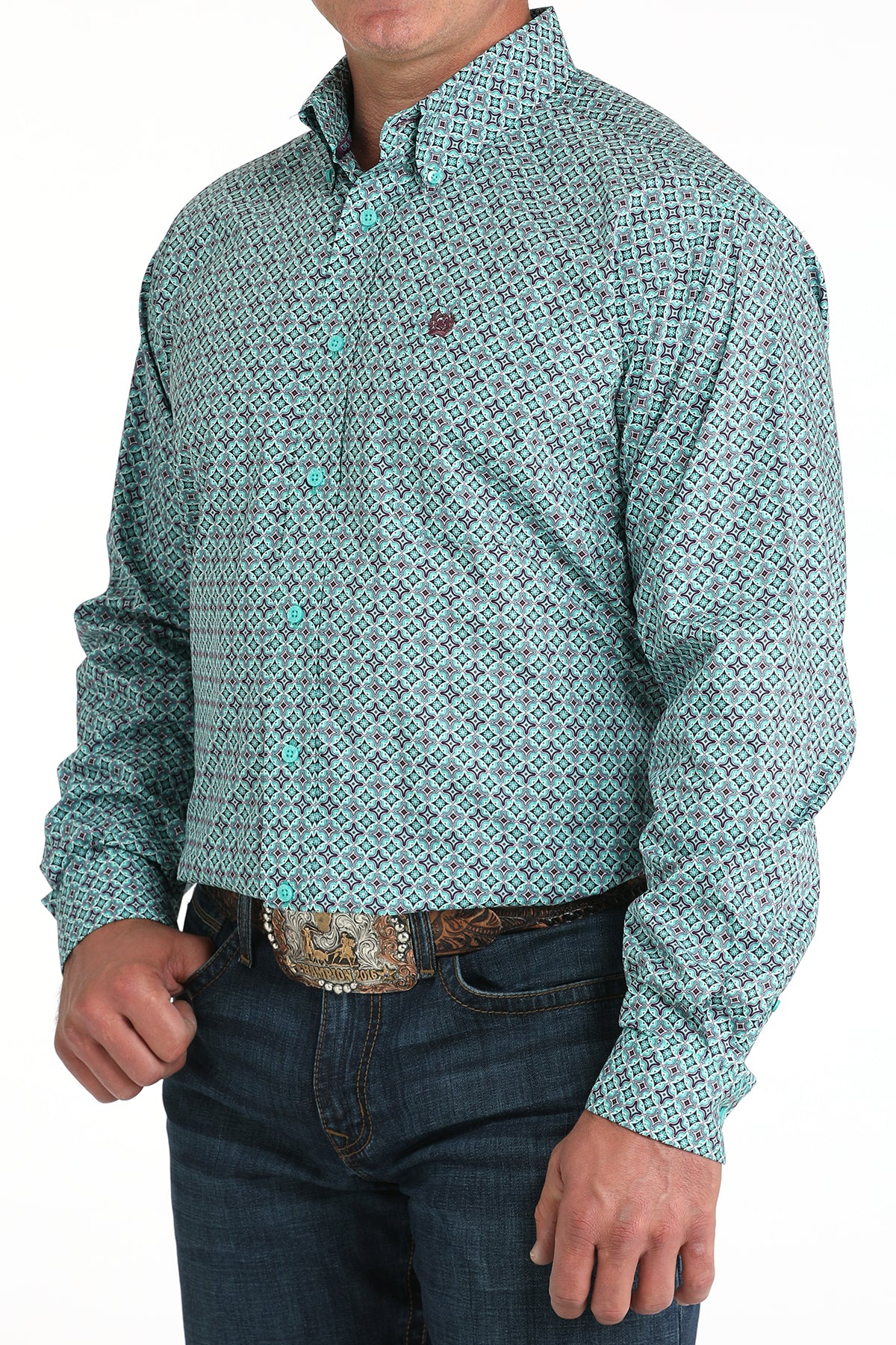 Man wearing a teal long sleeve button-down shirt with jeans and a belt