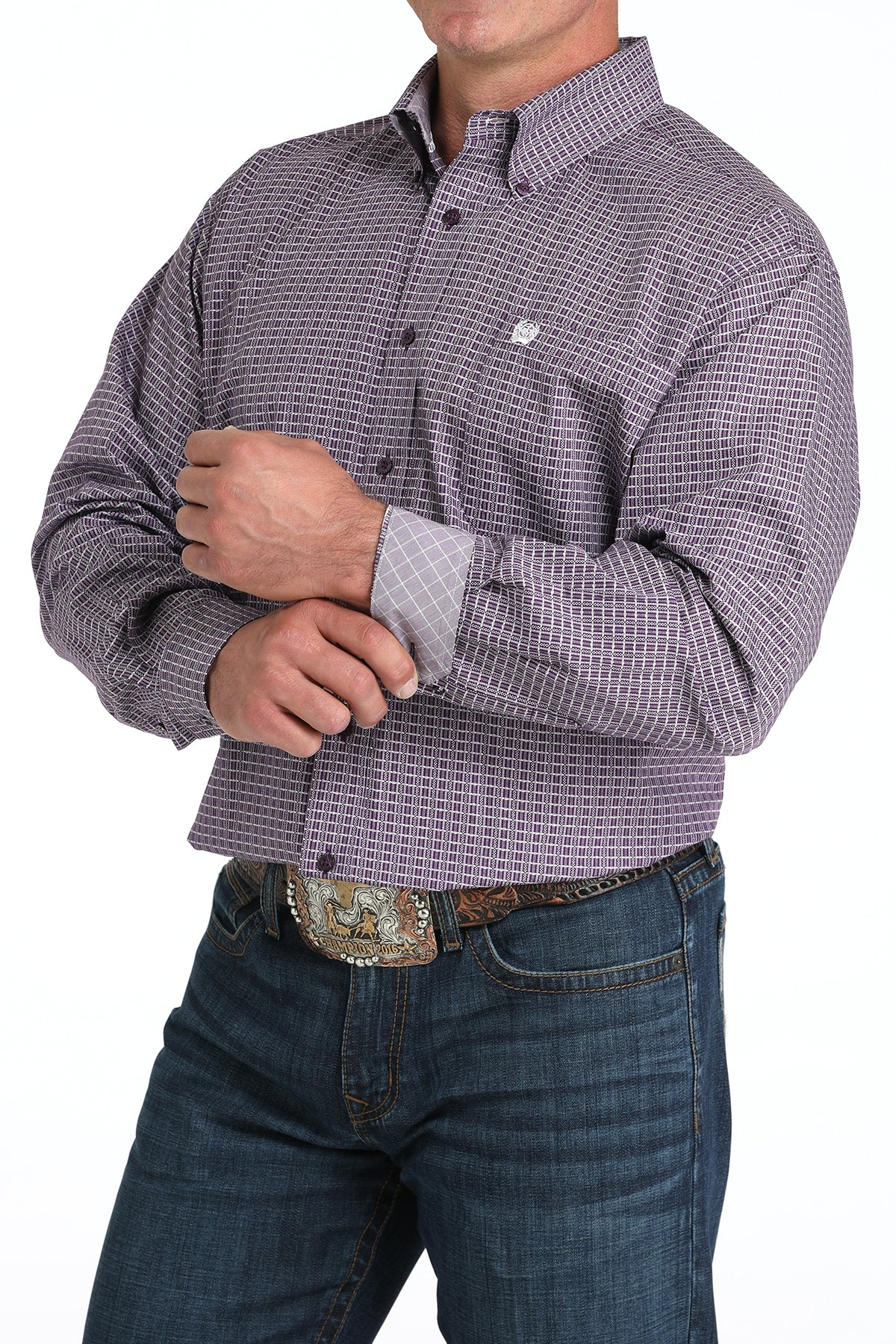 Man wearing a purple long sleeve button-down shirt with a contrasting cuff detail, paired with jeans and a belt
