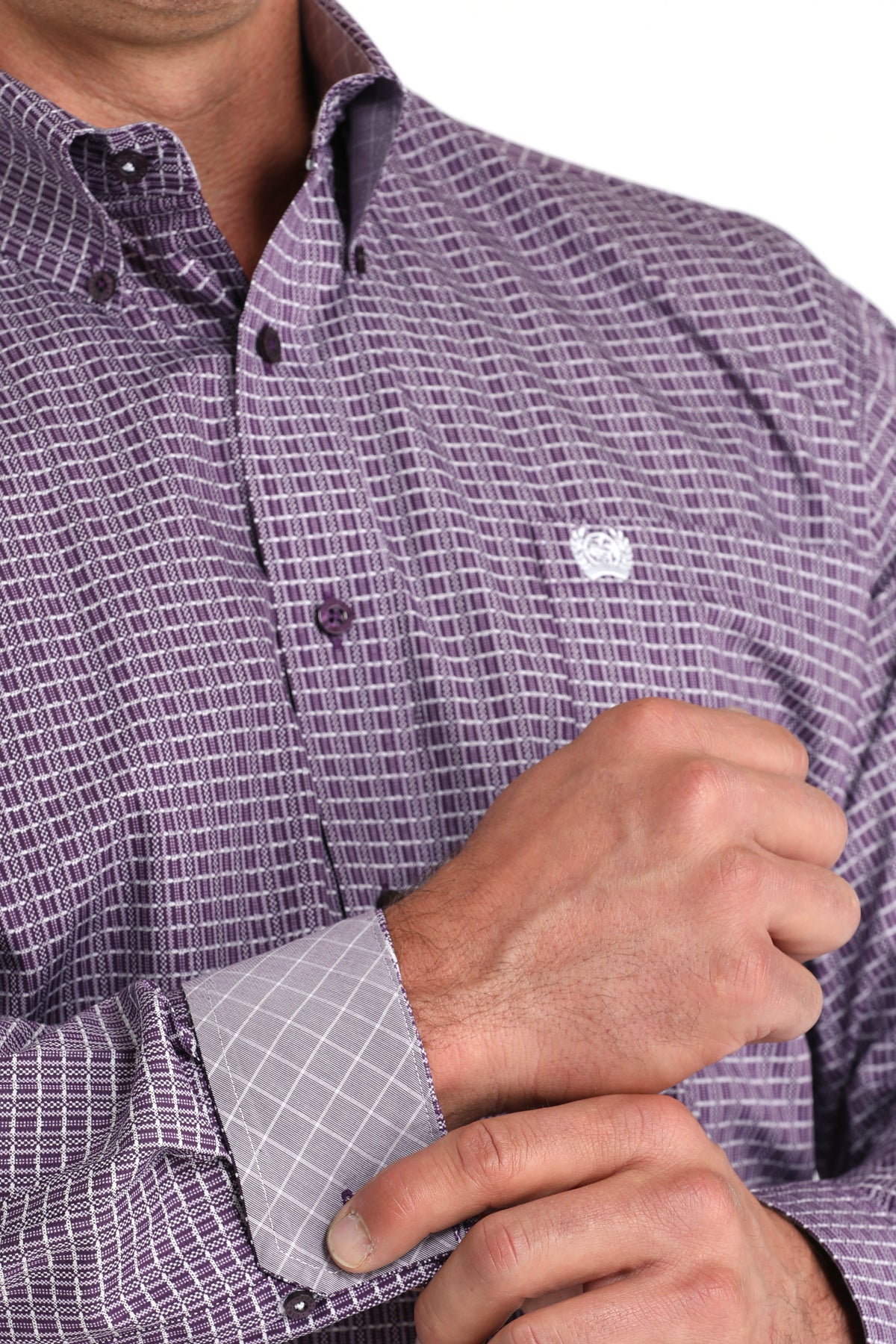 Close-up of  a man wearing a purple long sleeve button-down shirt with a contrasting cuff detail