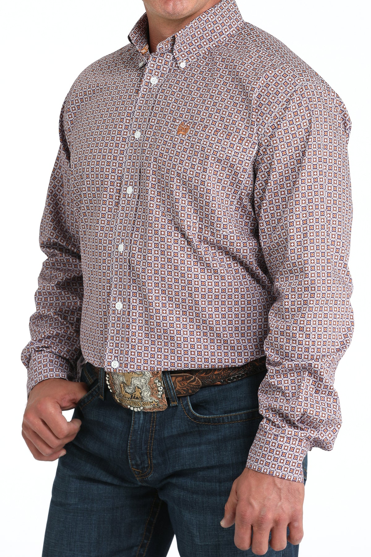 Man wearing a patterned purple long sleeve button-down shirt with jeans and a belt