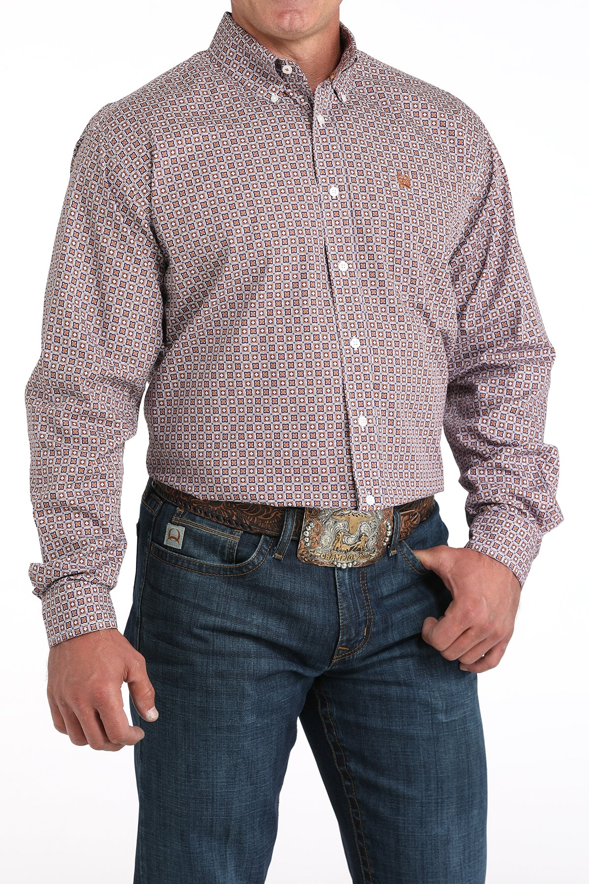 Man wearing a patterned purple long sleeve button-down shirt with jeans and a belt