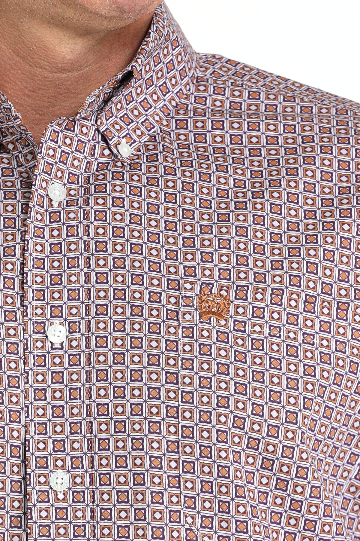 Close-up of a man wearing a patterned purple long sleeve button-down shirt